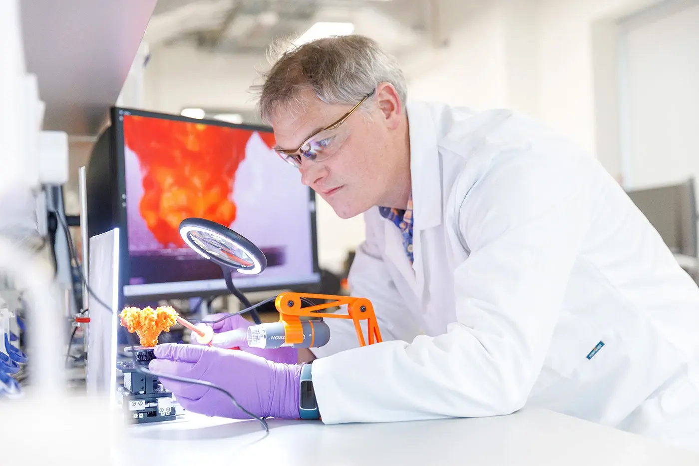 scientist looking through magnifying glass in a lab