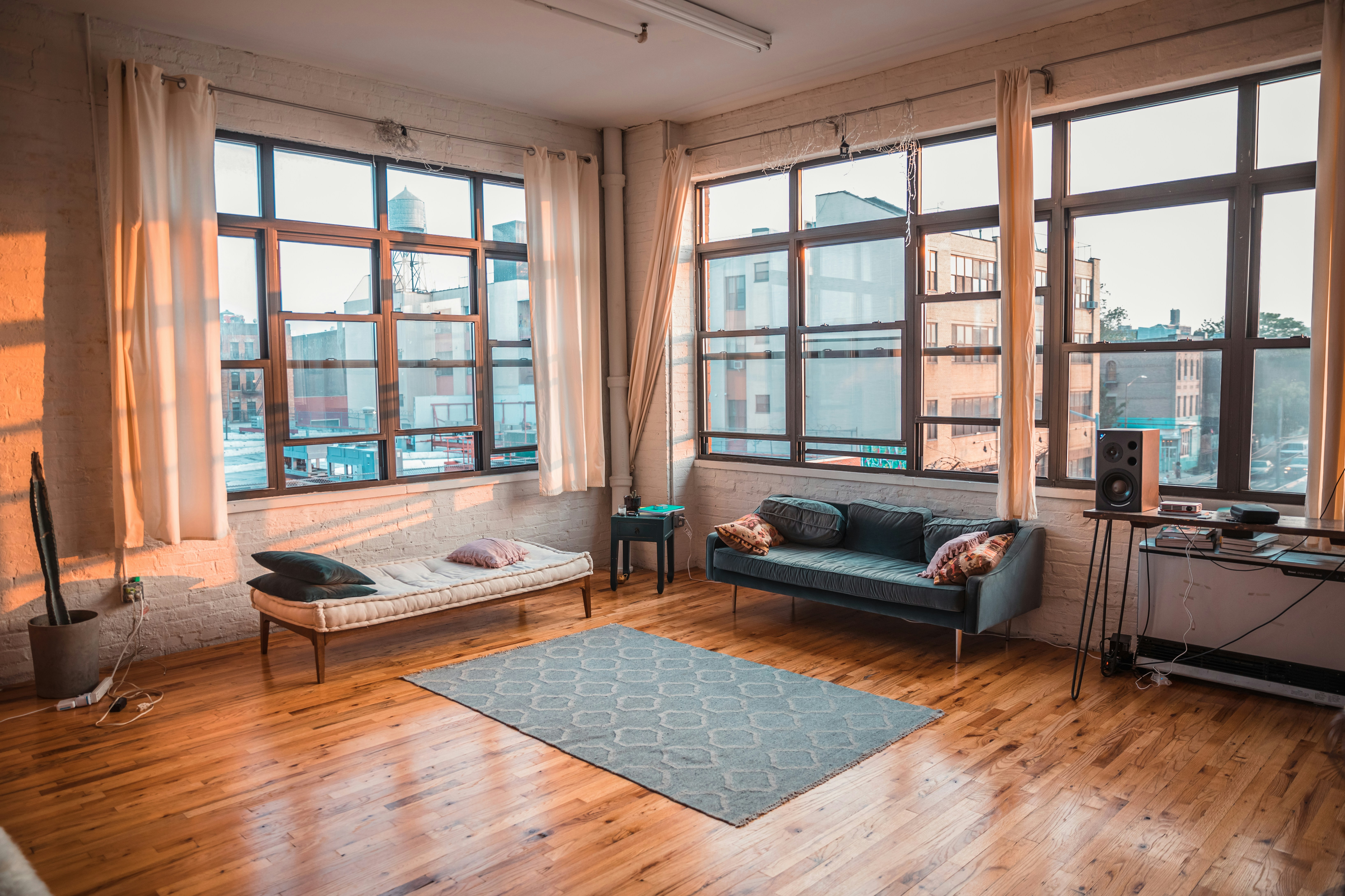 Spacious living room with large windows and hardwood floors.