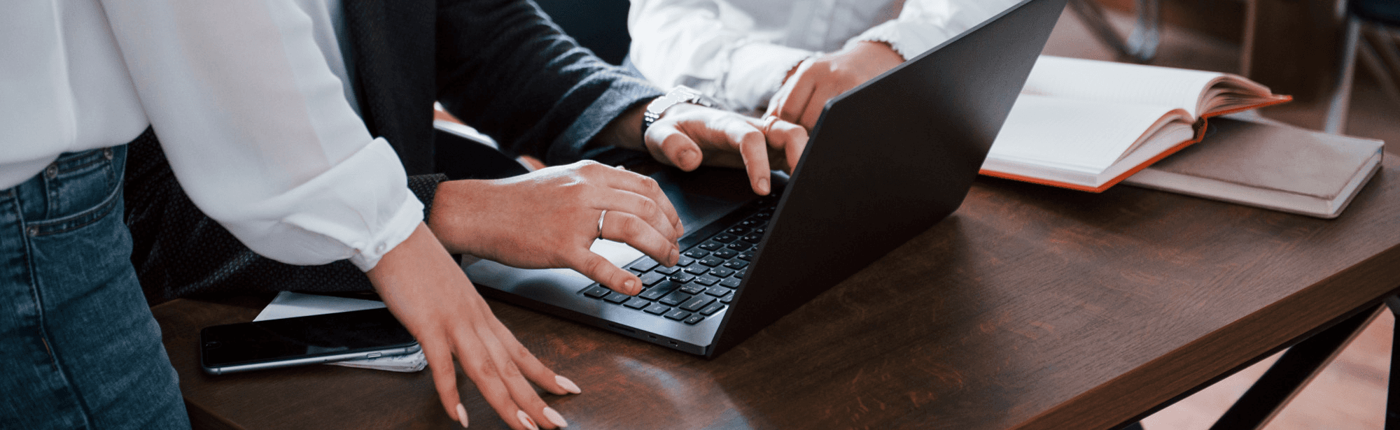A serene outdoor seating area with two chairs, surrounded by lush greenery and a glassed-in structure.