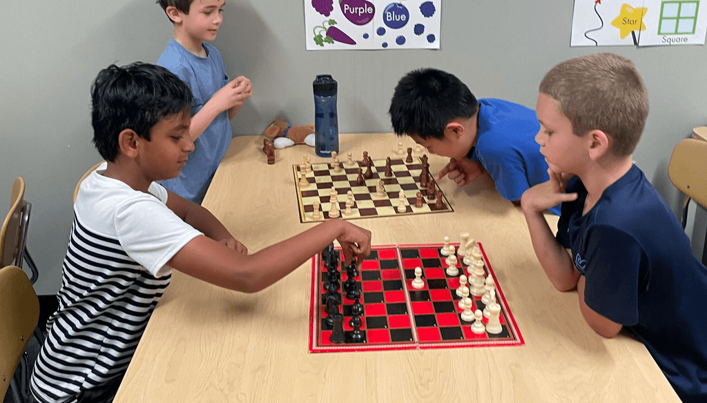 SportPlus Charlotte chess class with four boys playing chess against each other in our learning room 