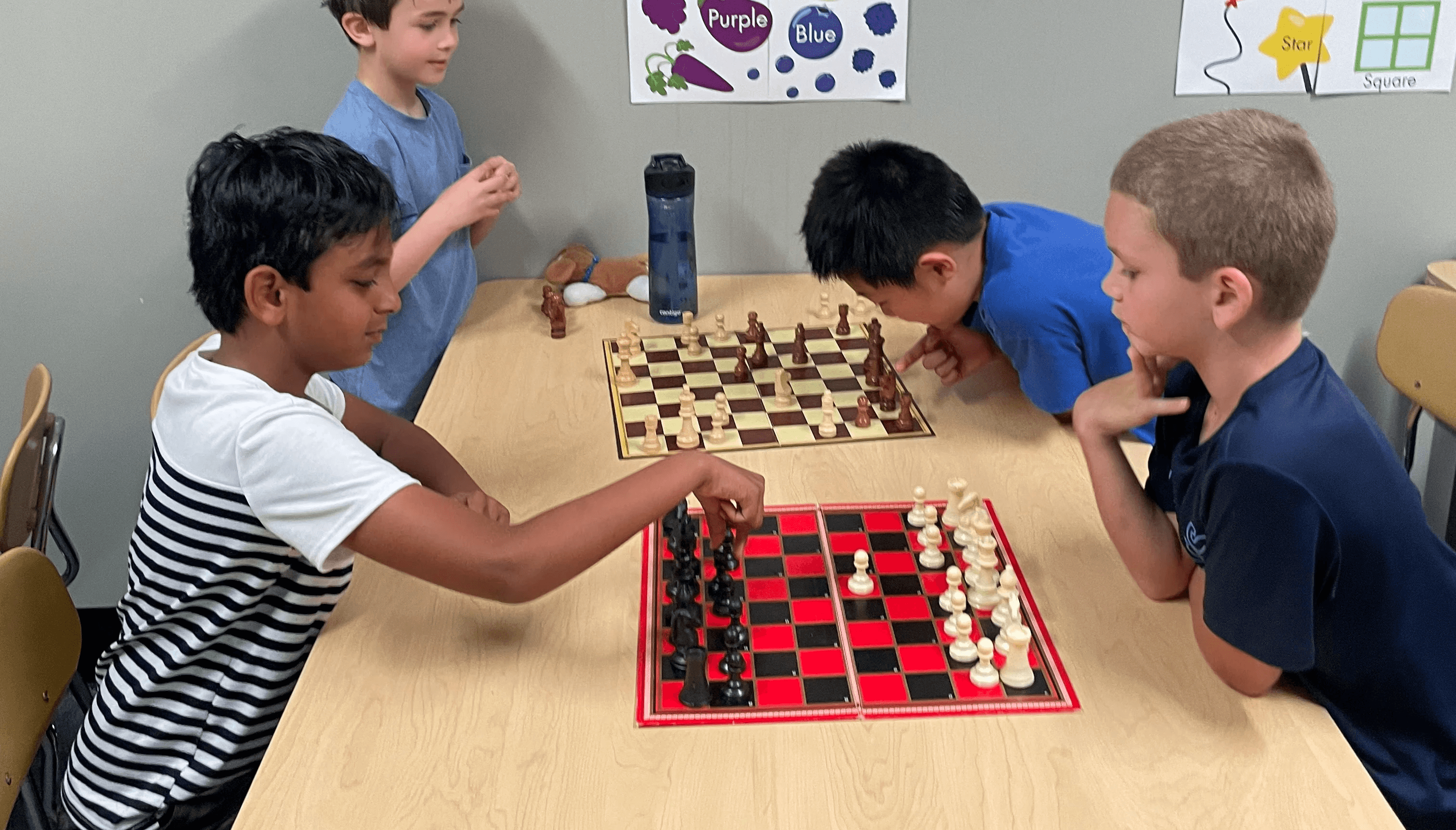 SportPlus Charlotte chess class with four boys playing chess against each other in our learning room