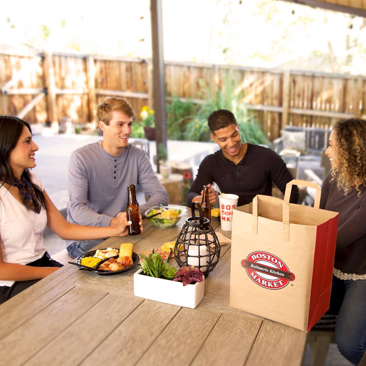 An overhead shot of a large oval plate featuring sliced, roasted duck, half glazed with a sauce, served over two thin pancakes and alongside steamed bok choy, surrounded by small bowls of condiments like scallions, sauce, salt, and carrot shreds.