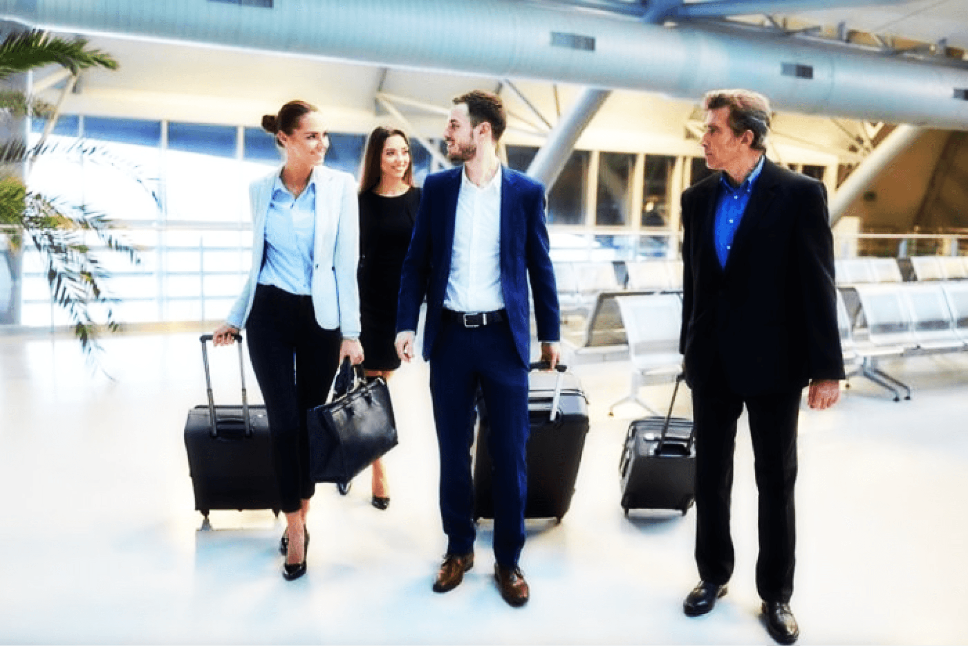 Group of happy business travellers walking through the airport.