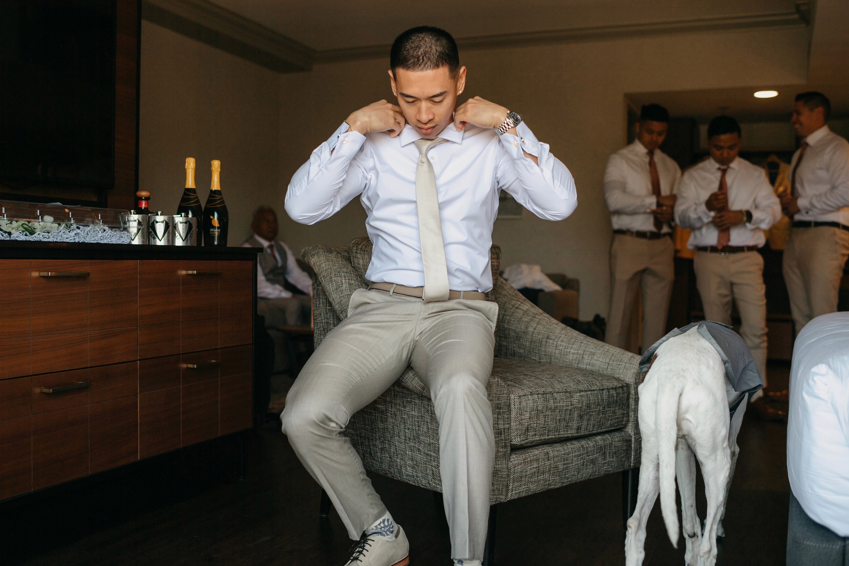 Groom adjusting tie during getting ready photos