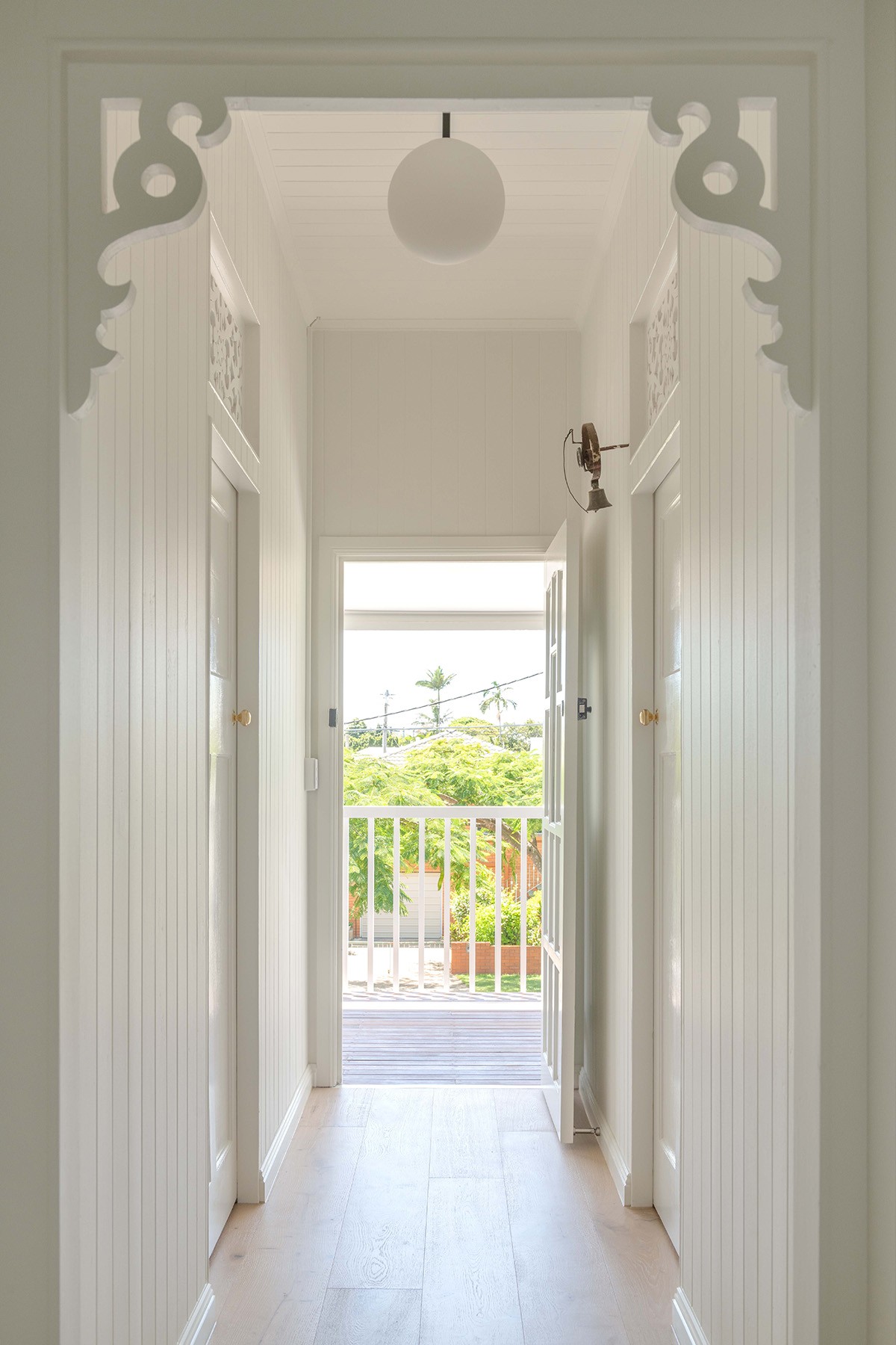 Restored hallway of the original cottage at The Stables, featuring decorative timber detailing, high ceilings, and a visual connection to the front verandah.