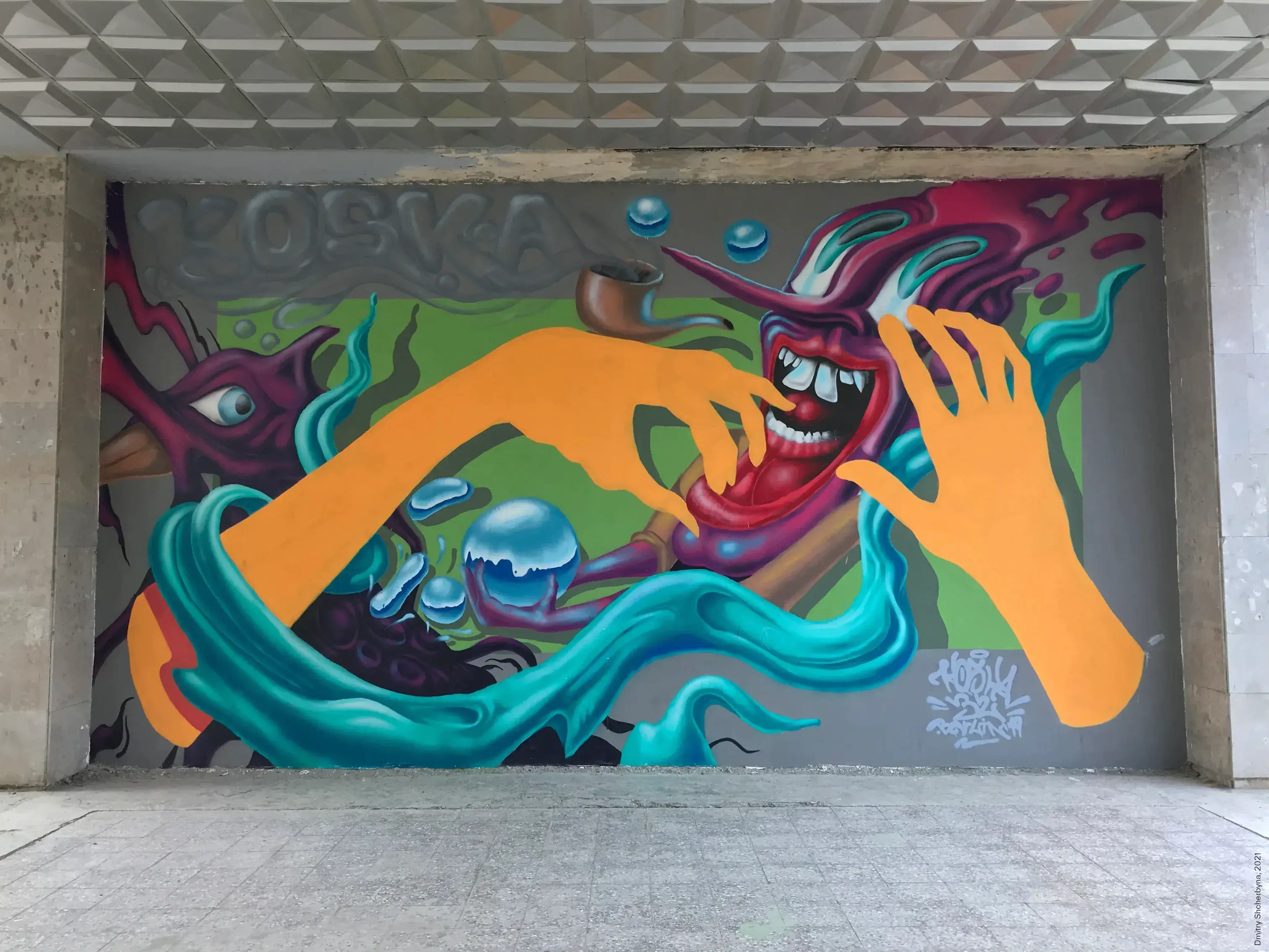 A mural showing a grinning disembodied red mouth with smoking pipe, flanked by long orange arms and hands surrounded by swirling teal shapes, floating blue orbs and a purple creature with single eye.