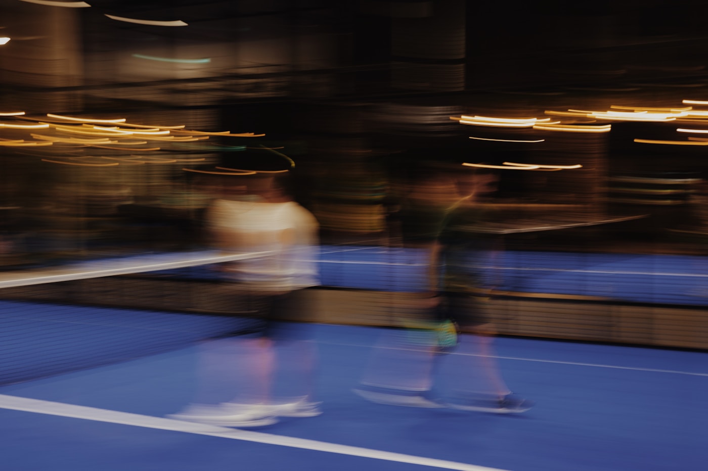 Blurred motion scene on a dark tennis court