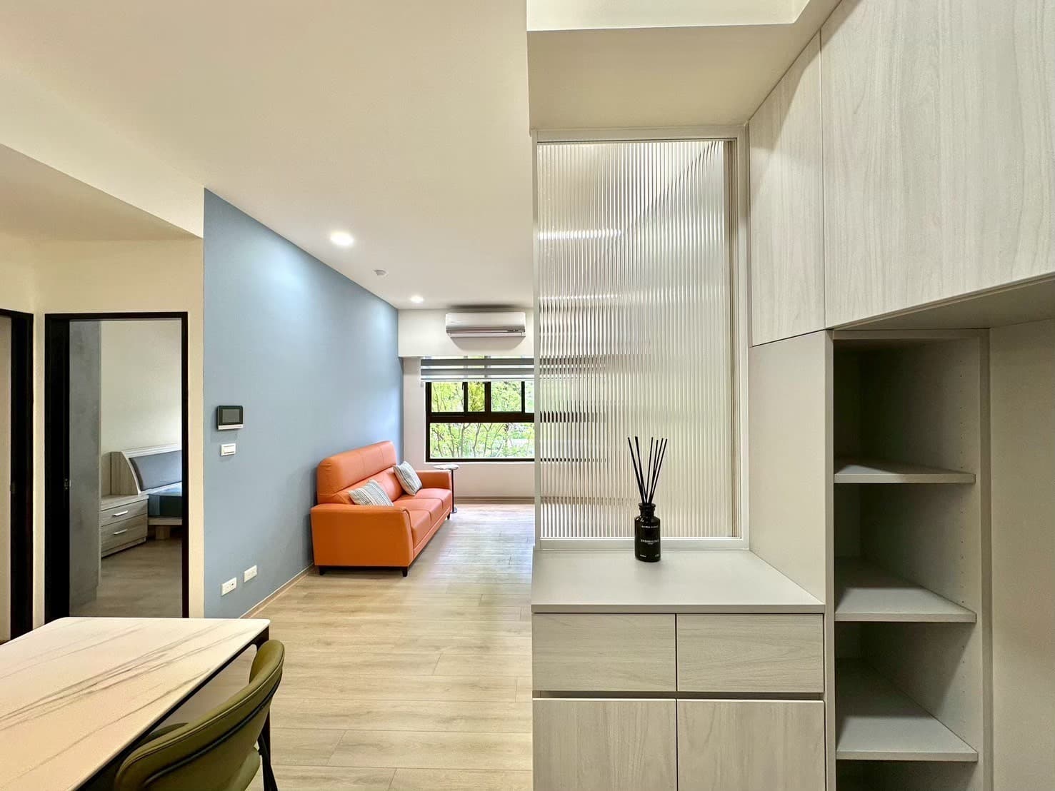 屋研所輕裝修｜小坪數客廳設計，藍色主牆搭配橘色沙發與系統櫃收納展示