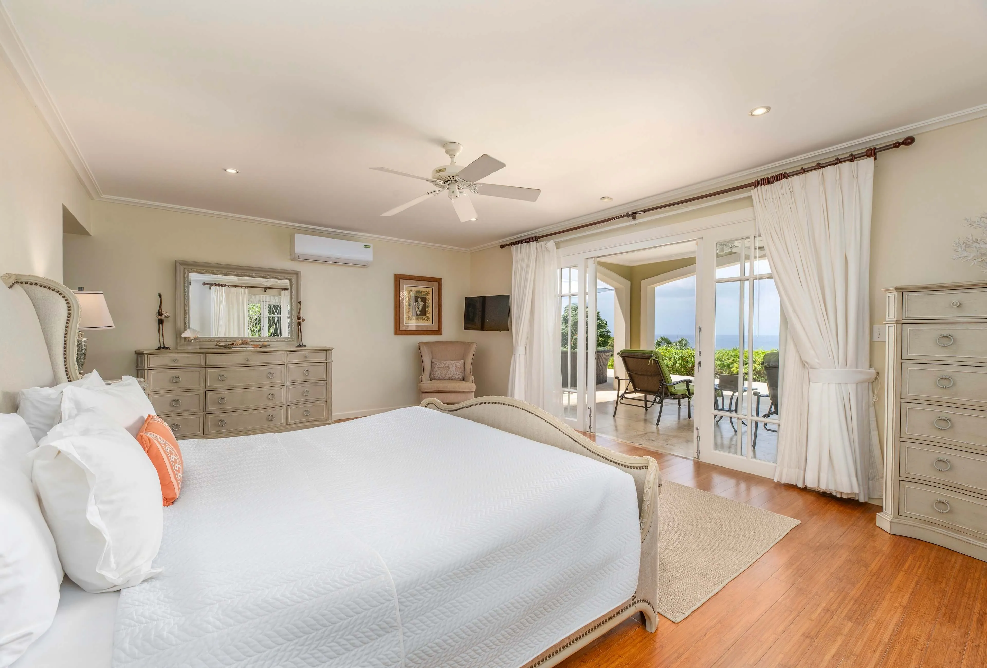 Bright bedroom with large windows and wooden floor