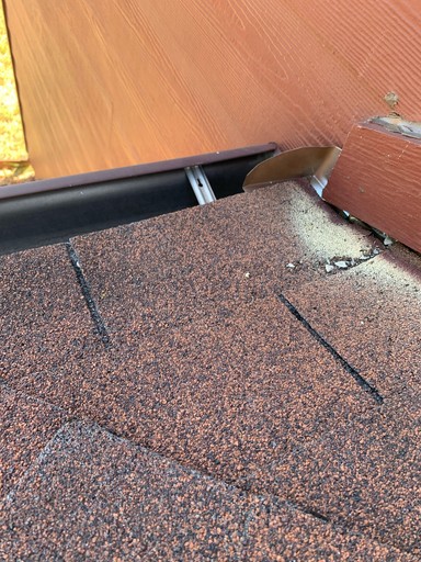 Flashing detail: kick-out flashing at the end of the roof-to-wall junction, beside a black gutter on the San Antonio repair project.