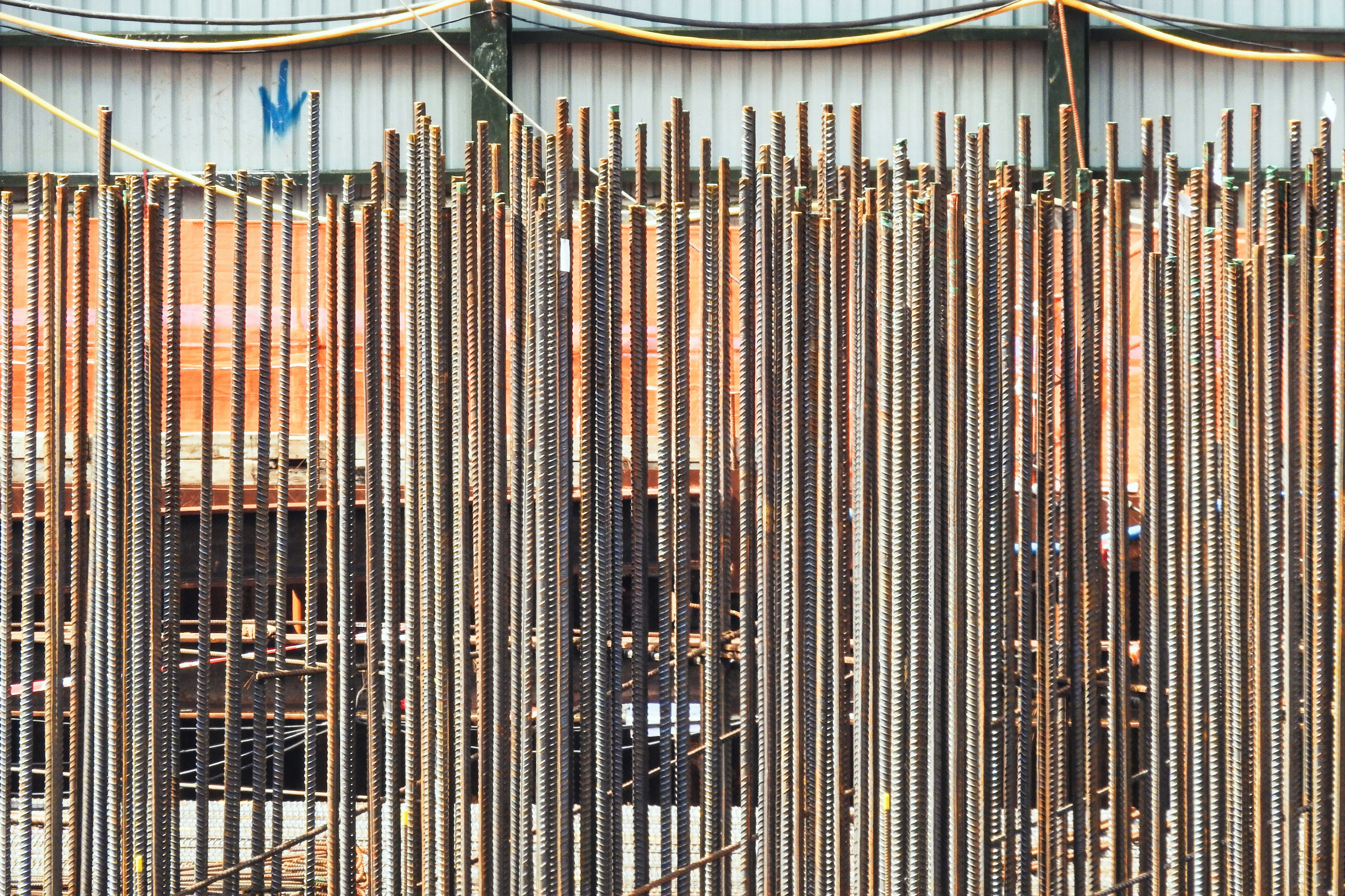 Construction worker inspects rebar on a building site.