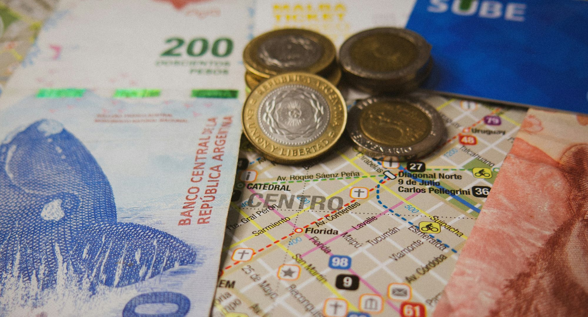 cédulas e moedas em cima de um mapa