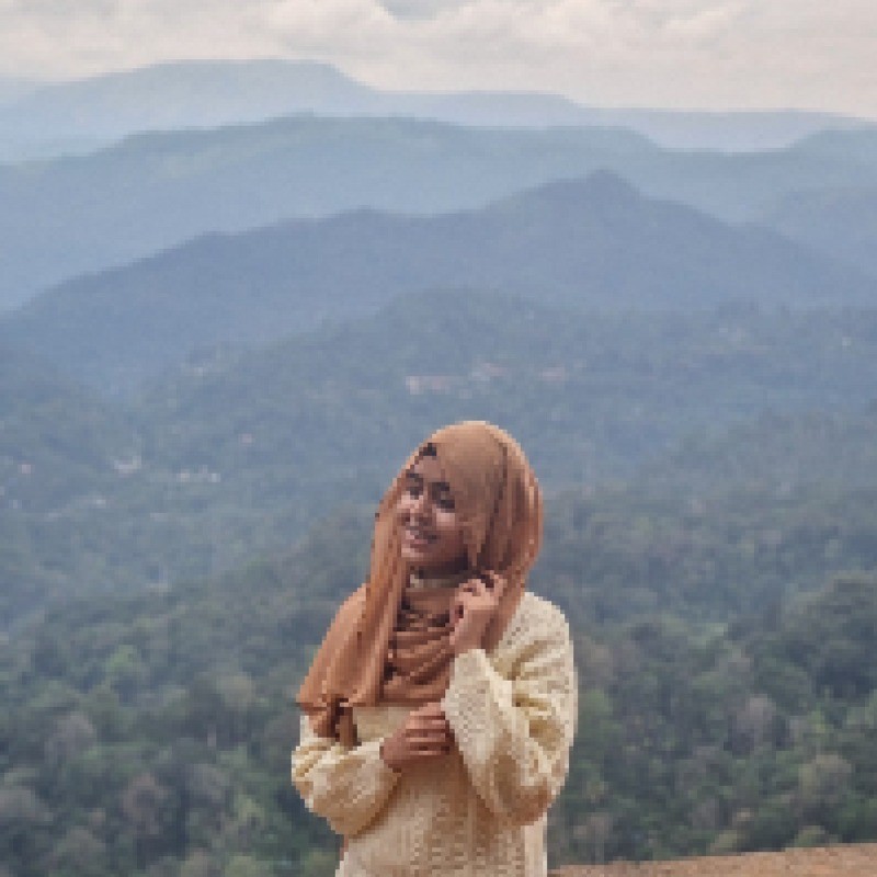 A person in a blue coat smiling