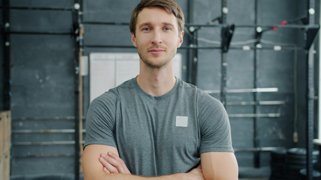 Man with arms crossed in a gym