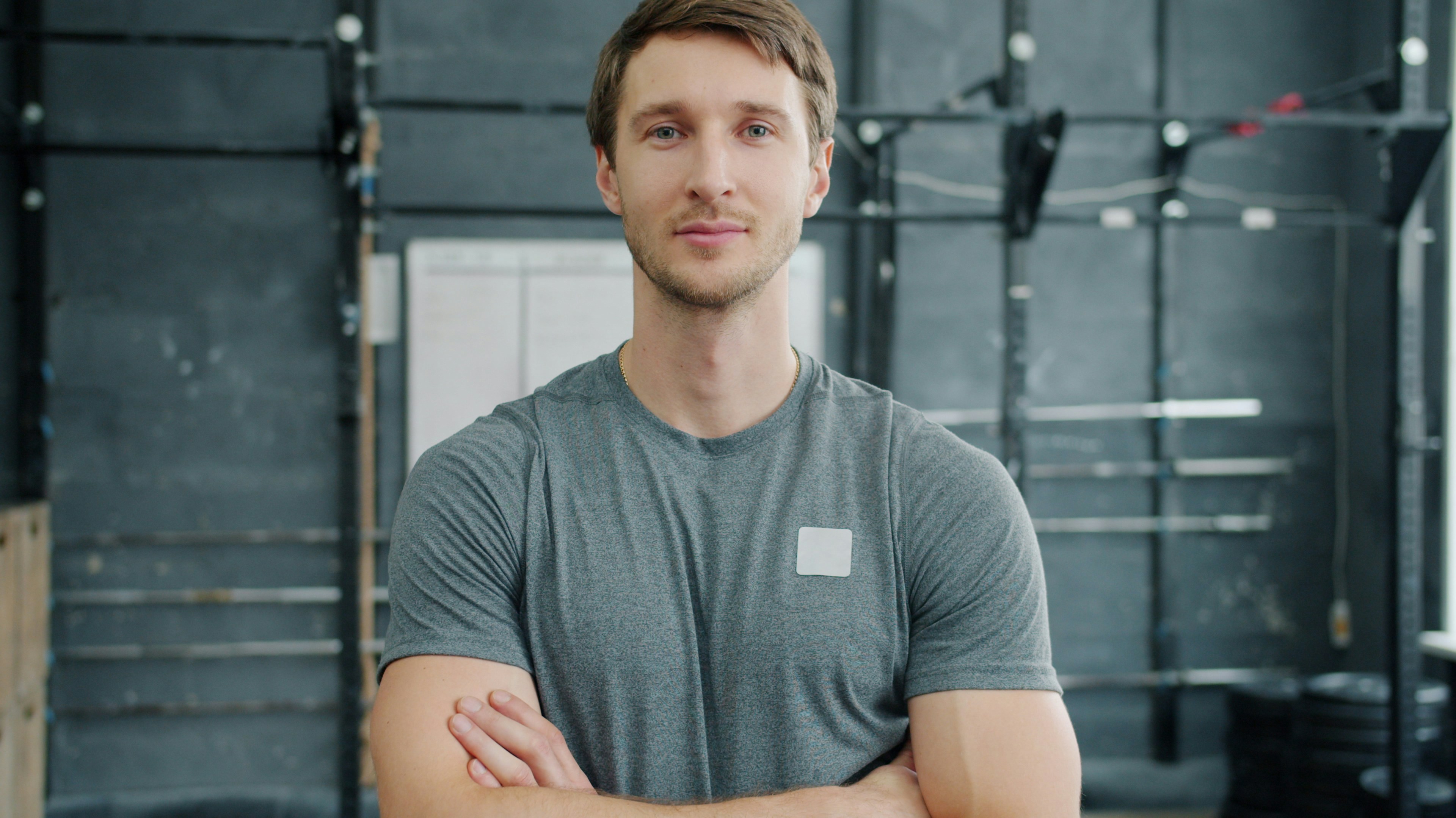 Man with arms crossed in a gym