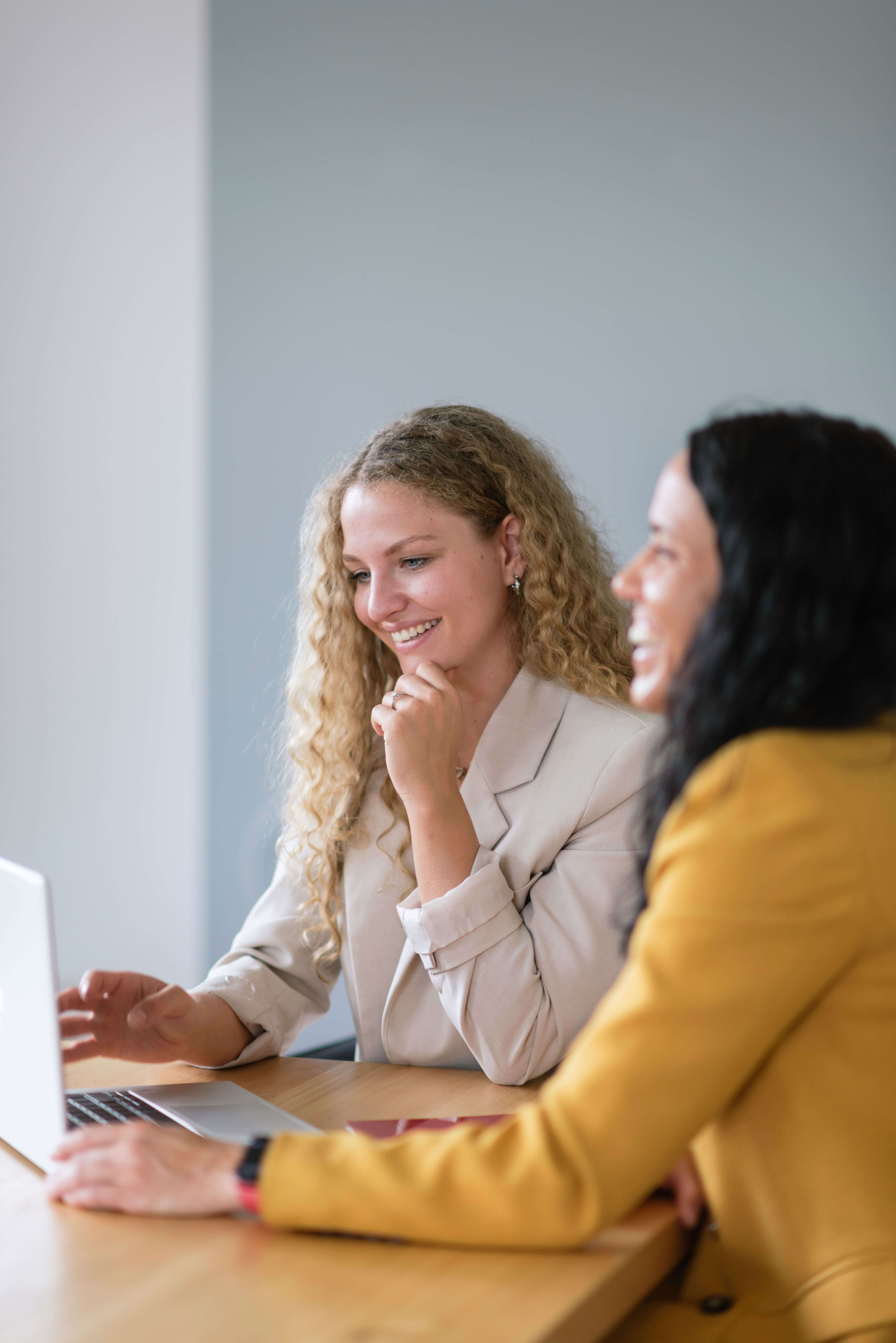 Two women from Team working together on a laptop, embodying the collaborative spirit of the company.