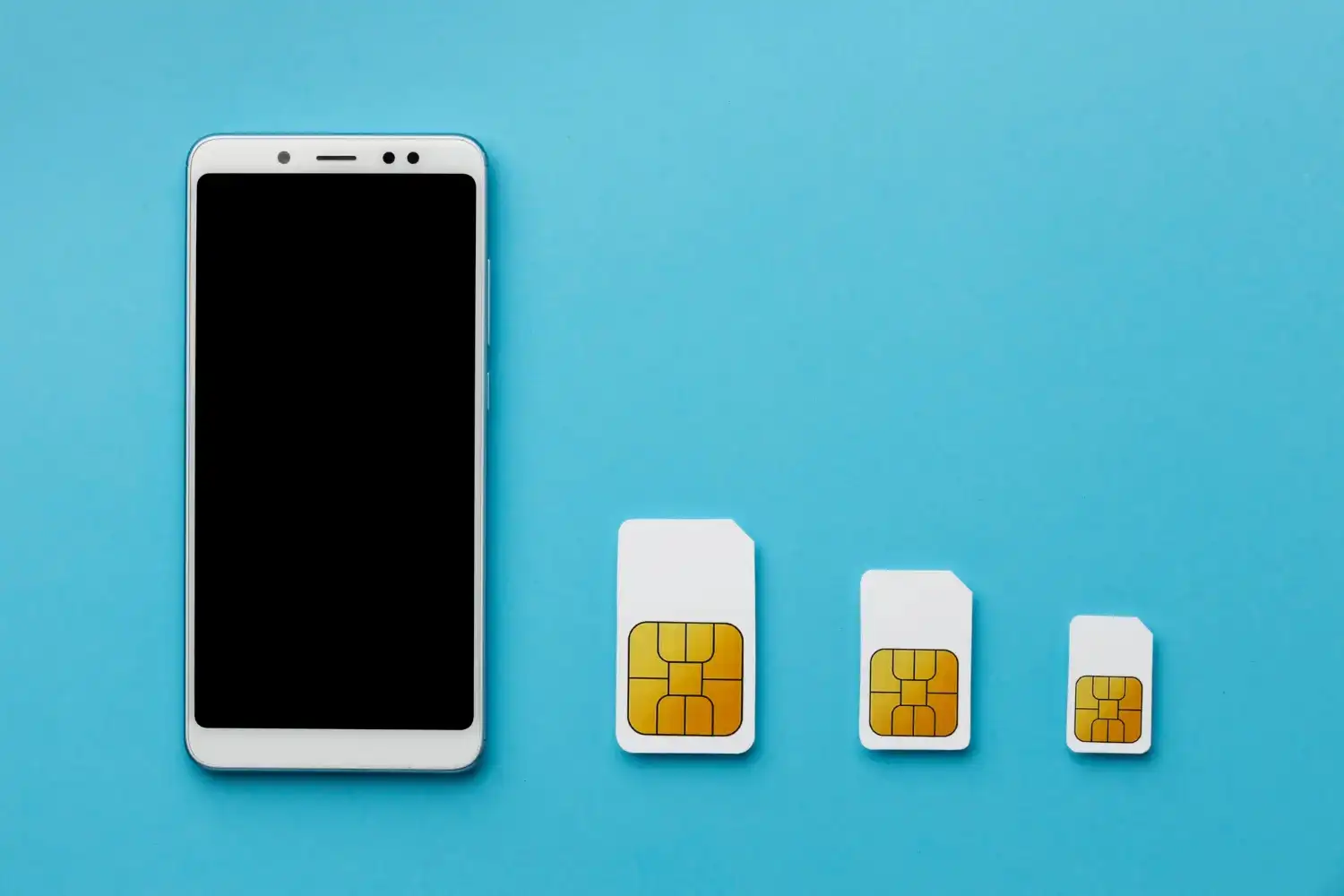 smartphone à côté de 3 types différents de cartes SIM physiques