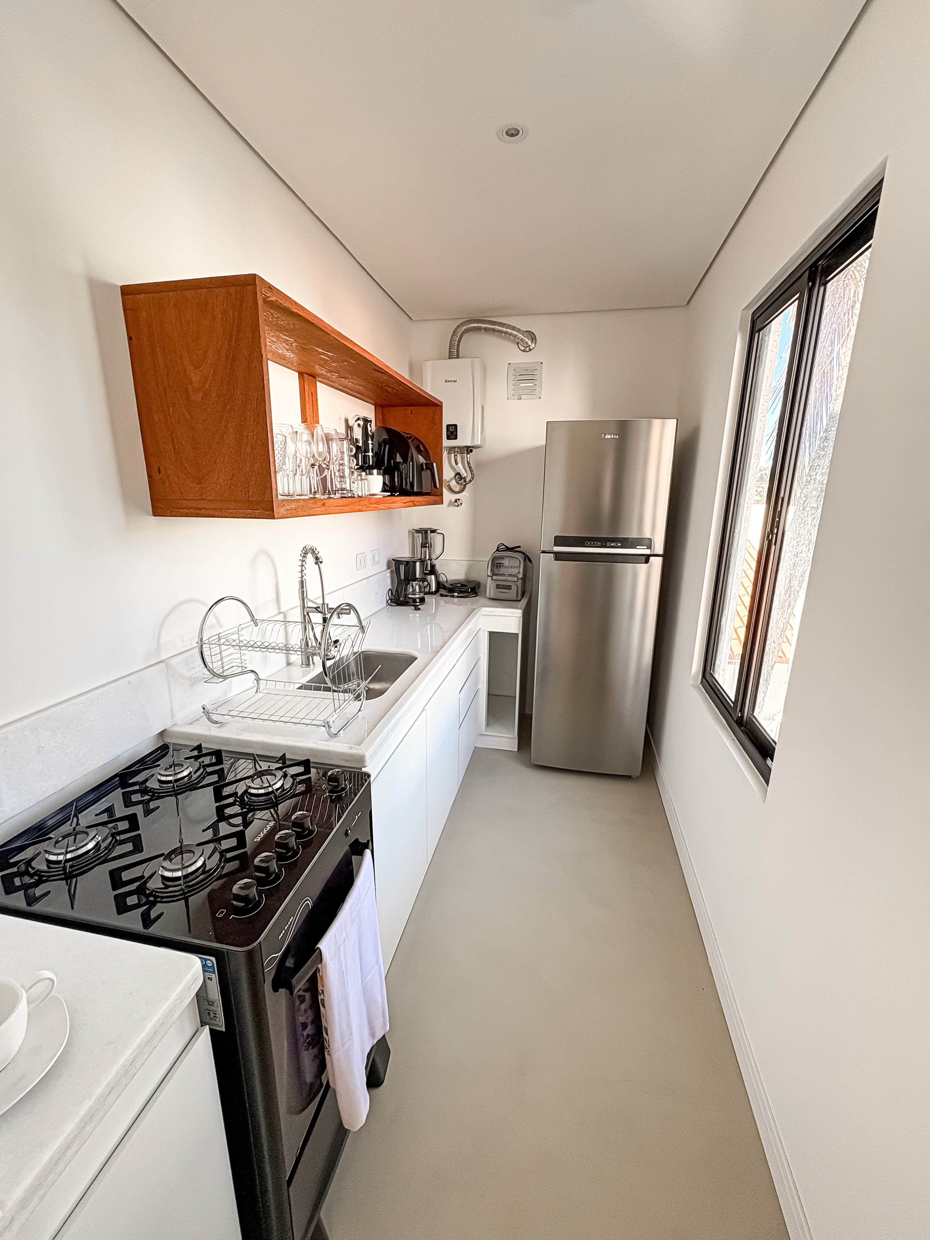 sleeping and living areas, king bed with layered neutral linens, elegant reading lights, and modern sofa with textured cushions