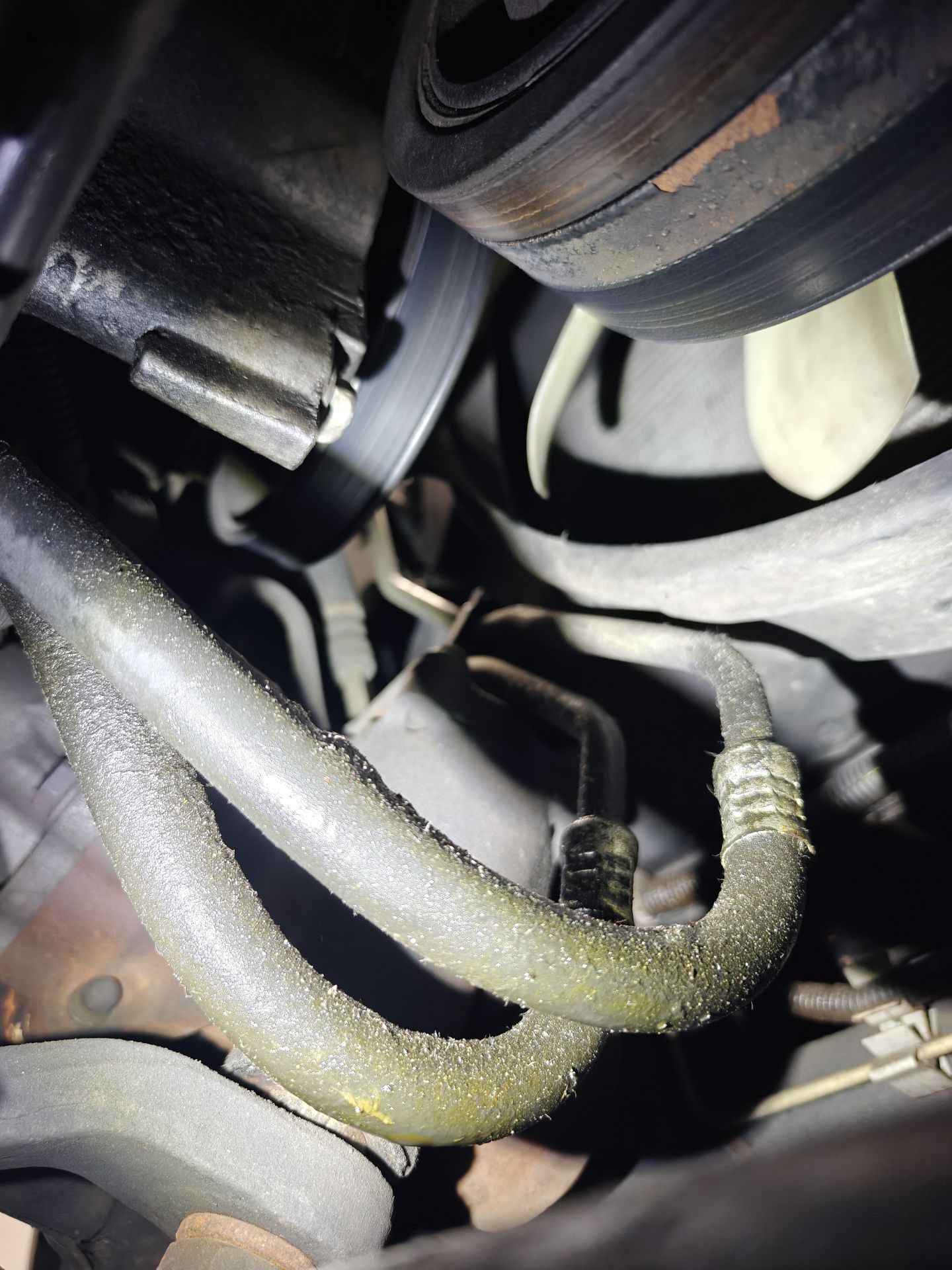 Oil cooler lines under the front of the Escalade’s engine, coated with oily residue