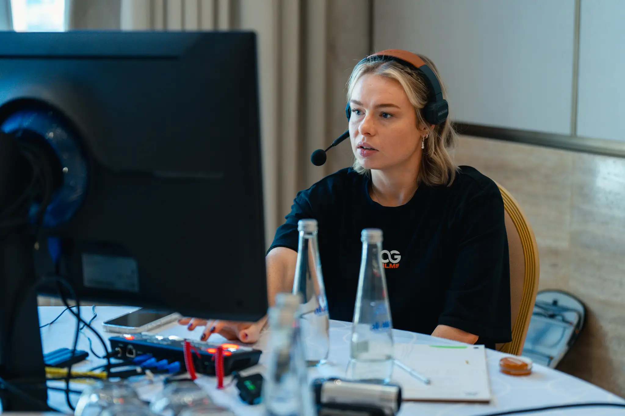 Portrait of a laughing person with curly hair wearing a white shirt