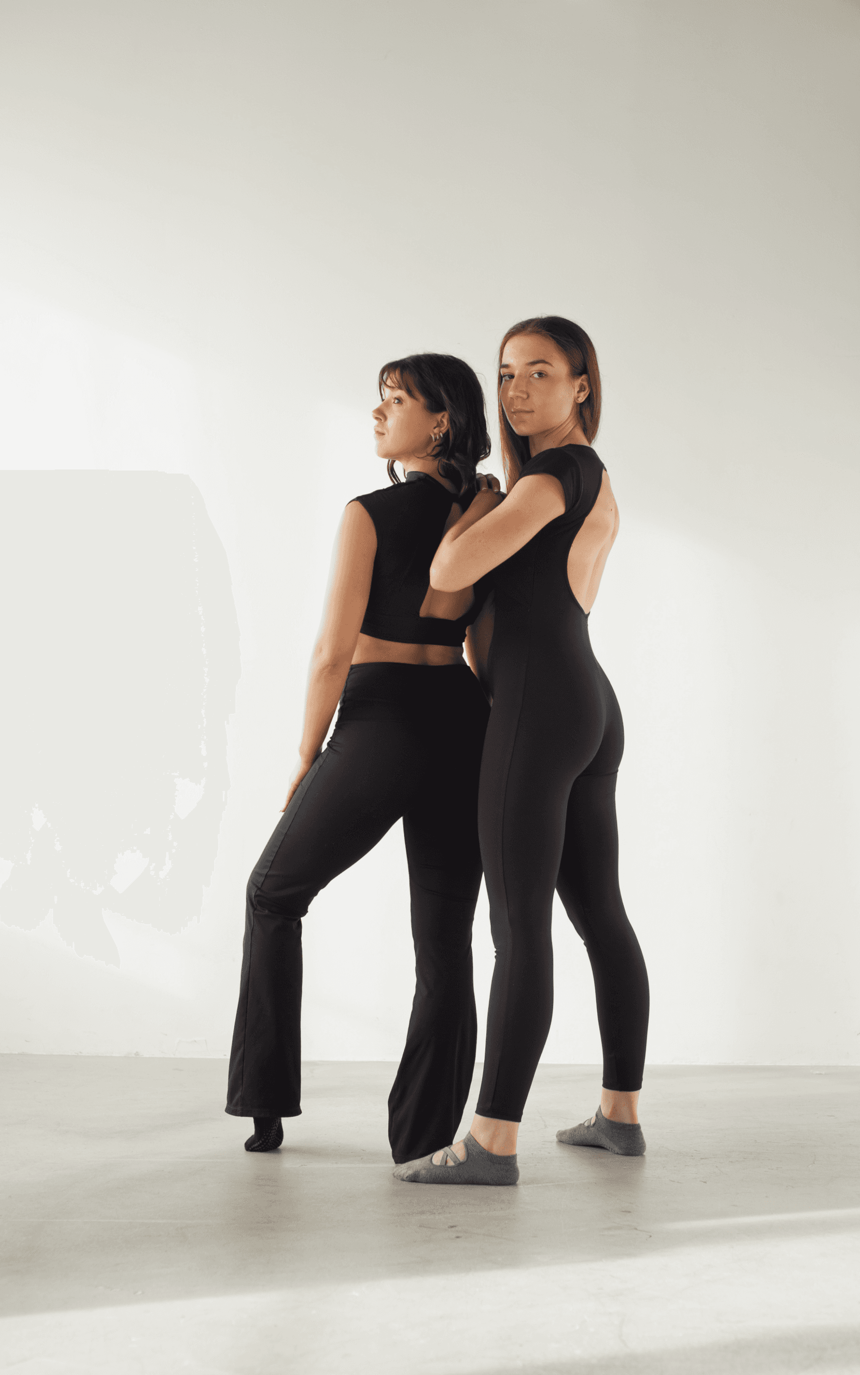 dwie kobiety w czarnych strojach do pilatesu