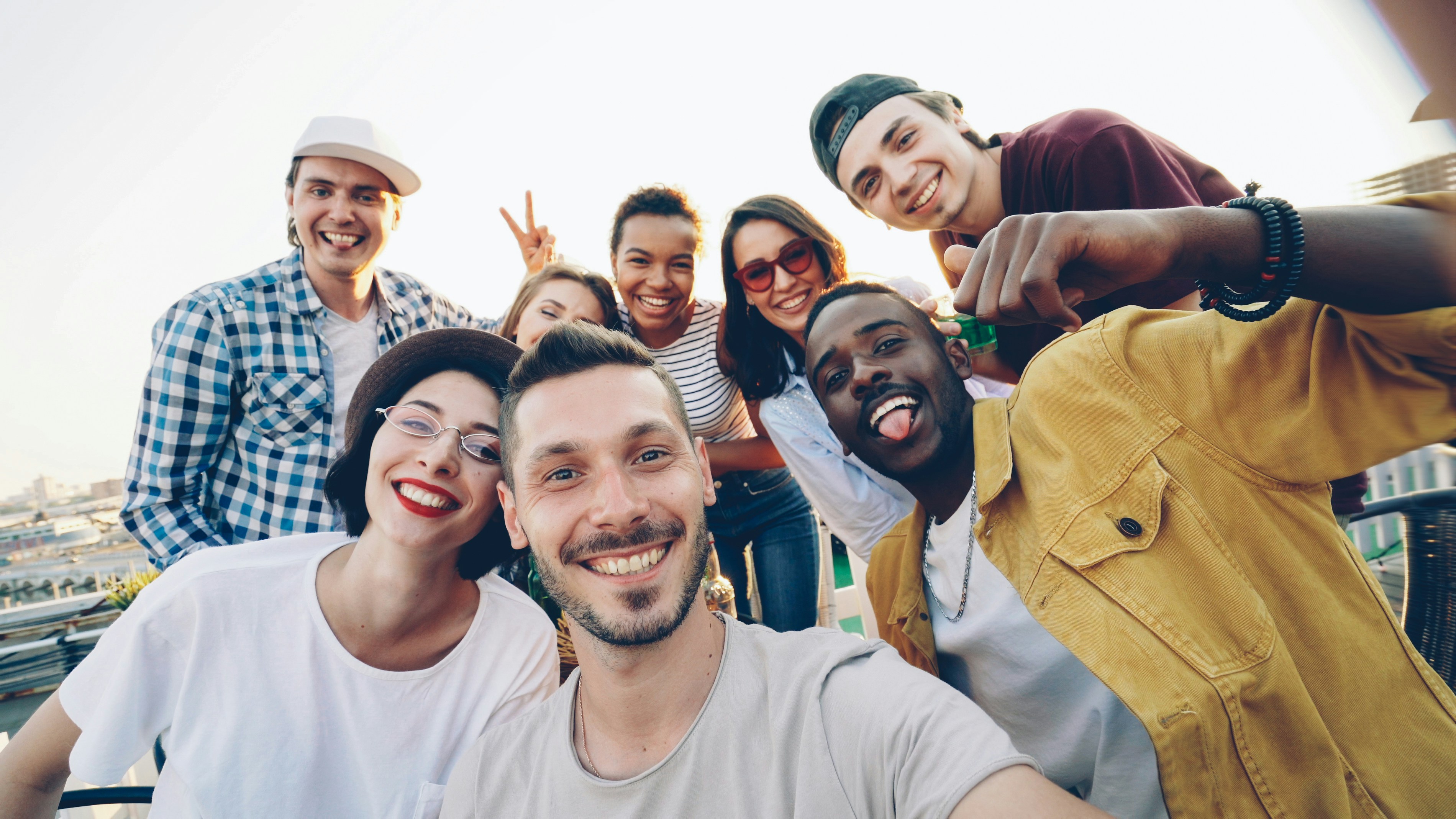 A diverse group of friends taking a selfie outdoors.