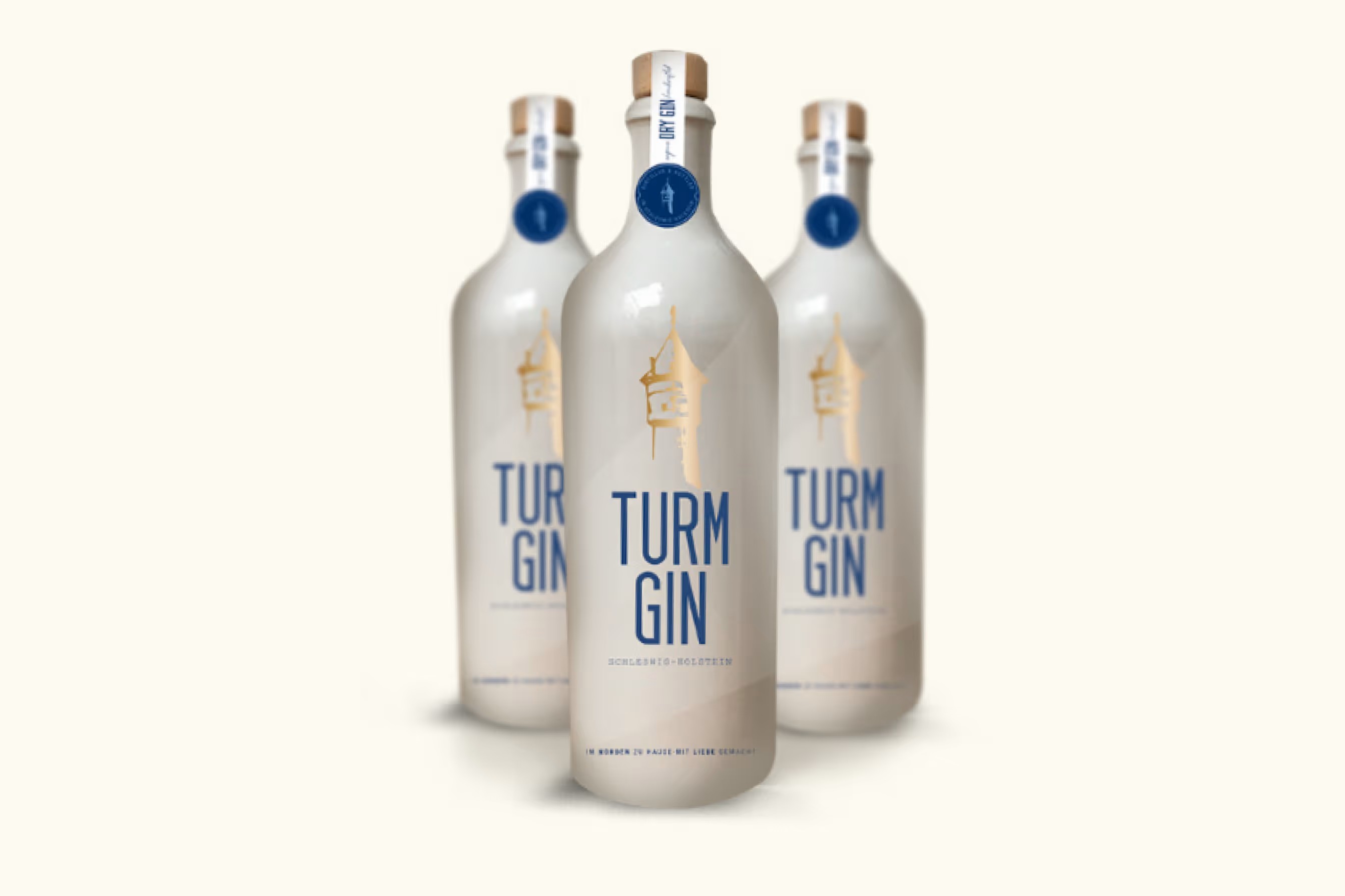 Drei weiße Tonflaschen mit Korkverschluss und blauer Siegelmarke, die drei Flaschen mit der Aufschrift 'TURM GIN' und goldener Turm-Silhouette