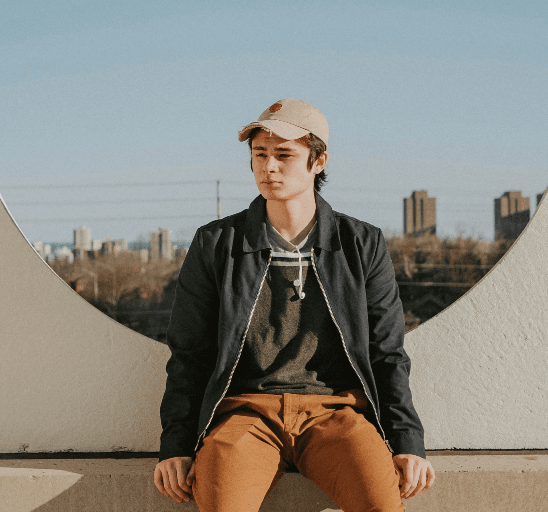 man sitting on gray concrete wall