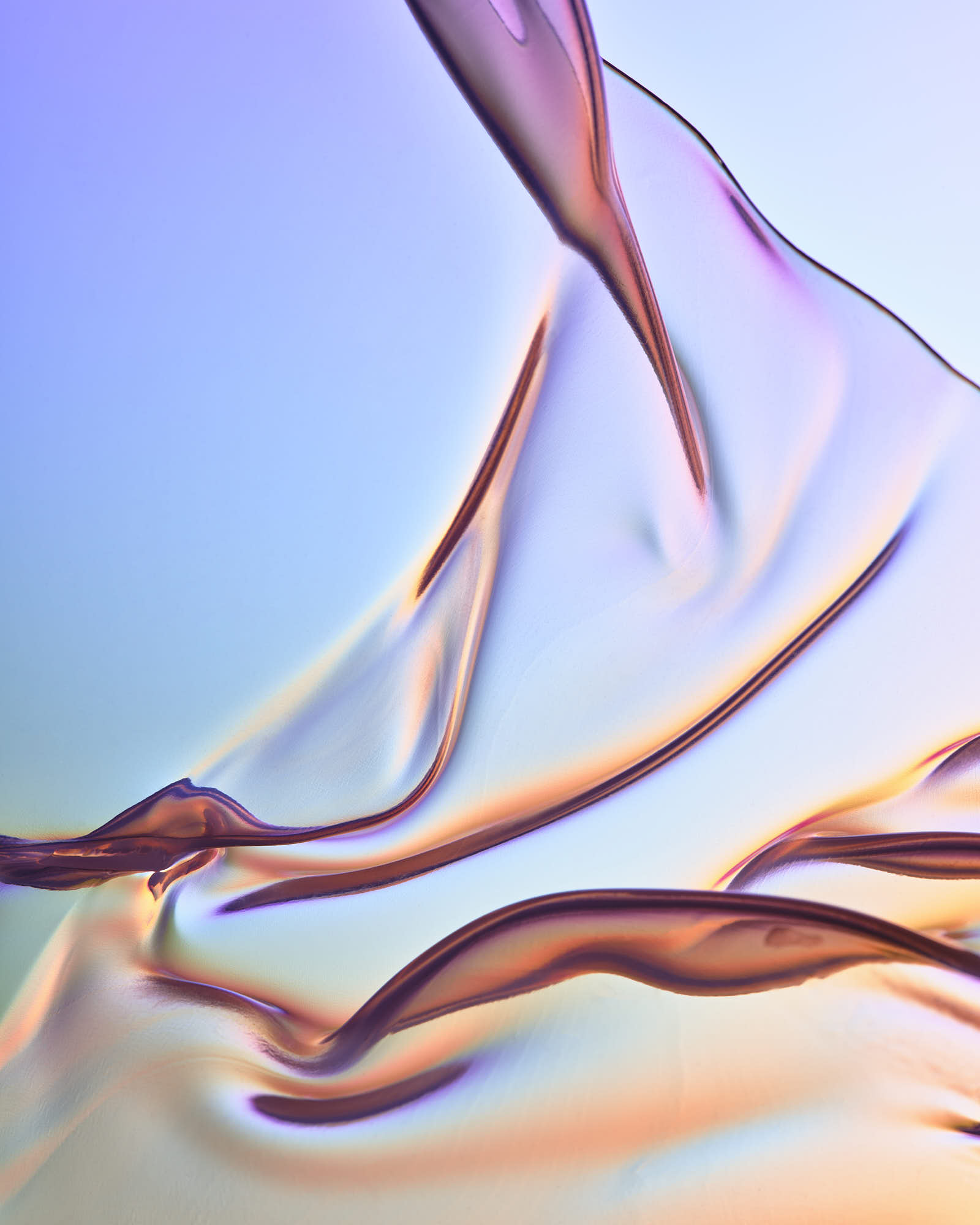 Soft, flowing fabric with a gradient of pastel colors against a light background, creating a serene, abstract effect.