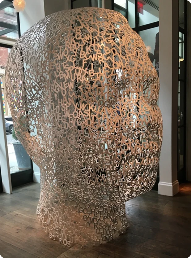 Sculpture of a human head made of letters, representing thoughtful leadership and communication