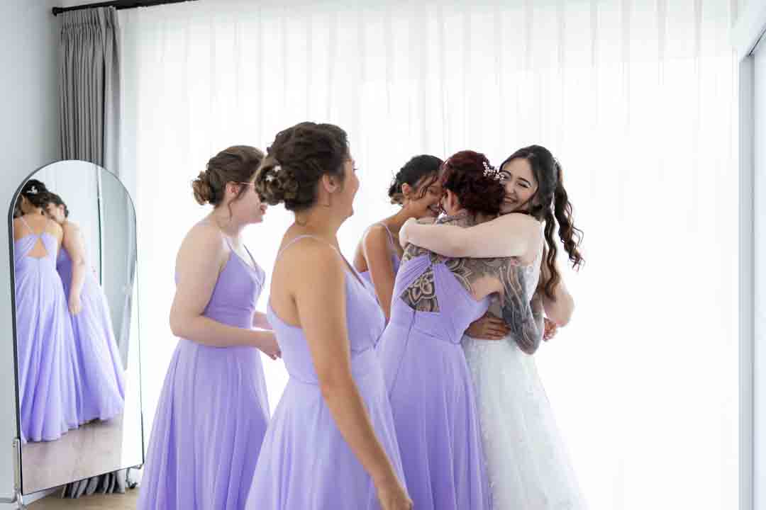 Bride hugging bridesmaids