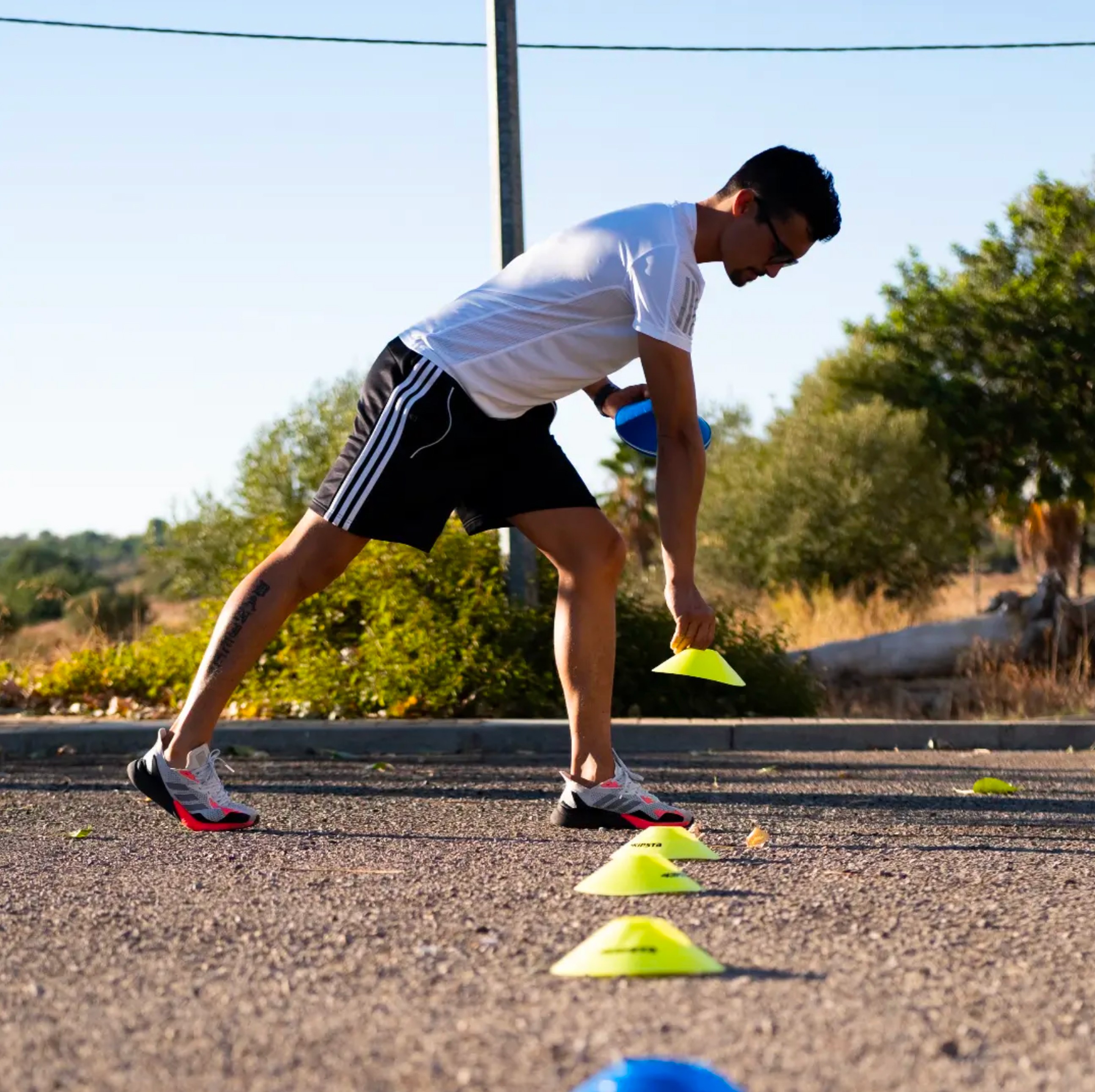 Man setting up cones for exercise.