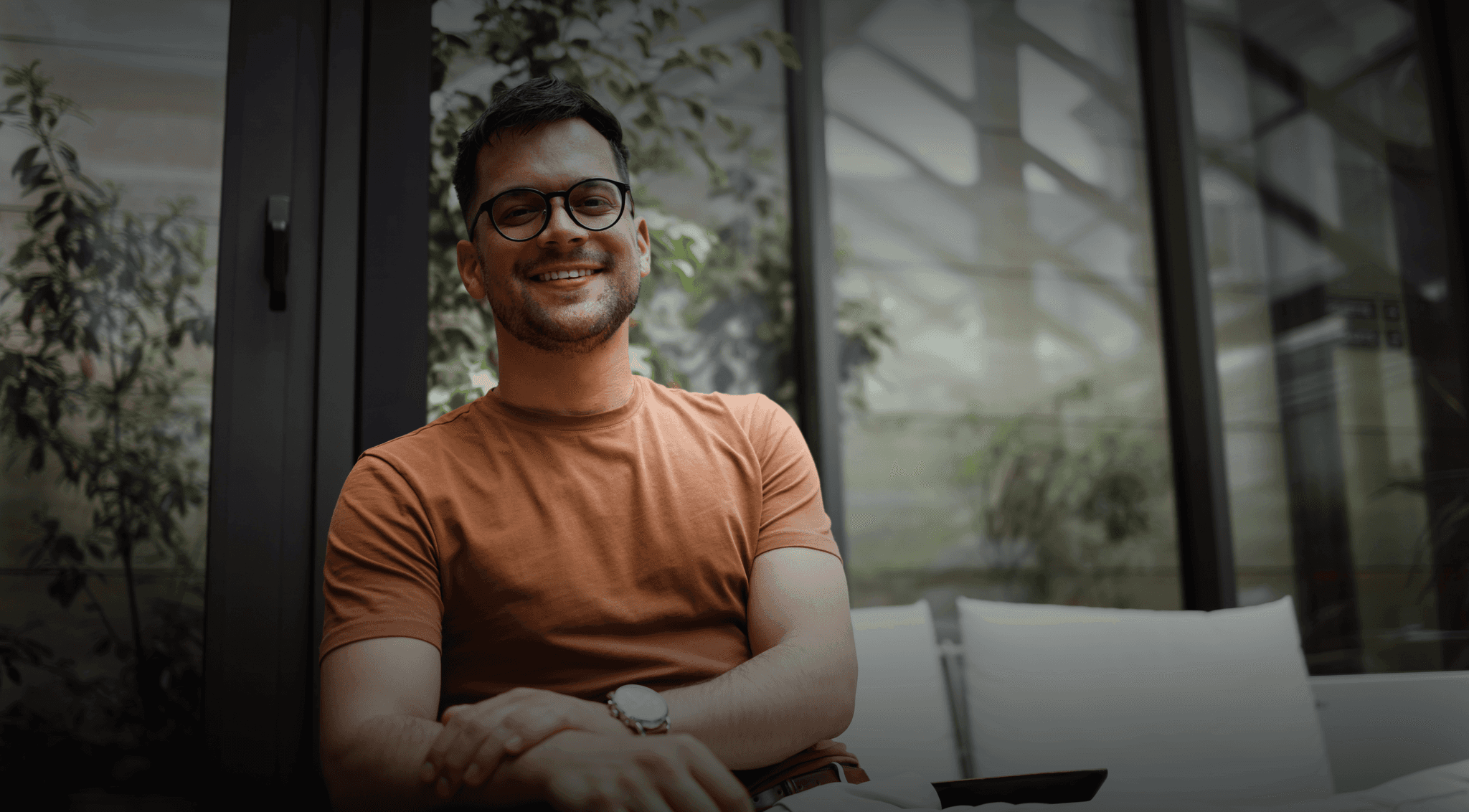 Young businessman sitting on a chair smiling at the camera