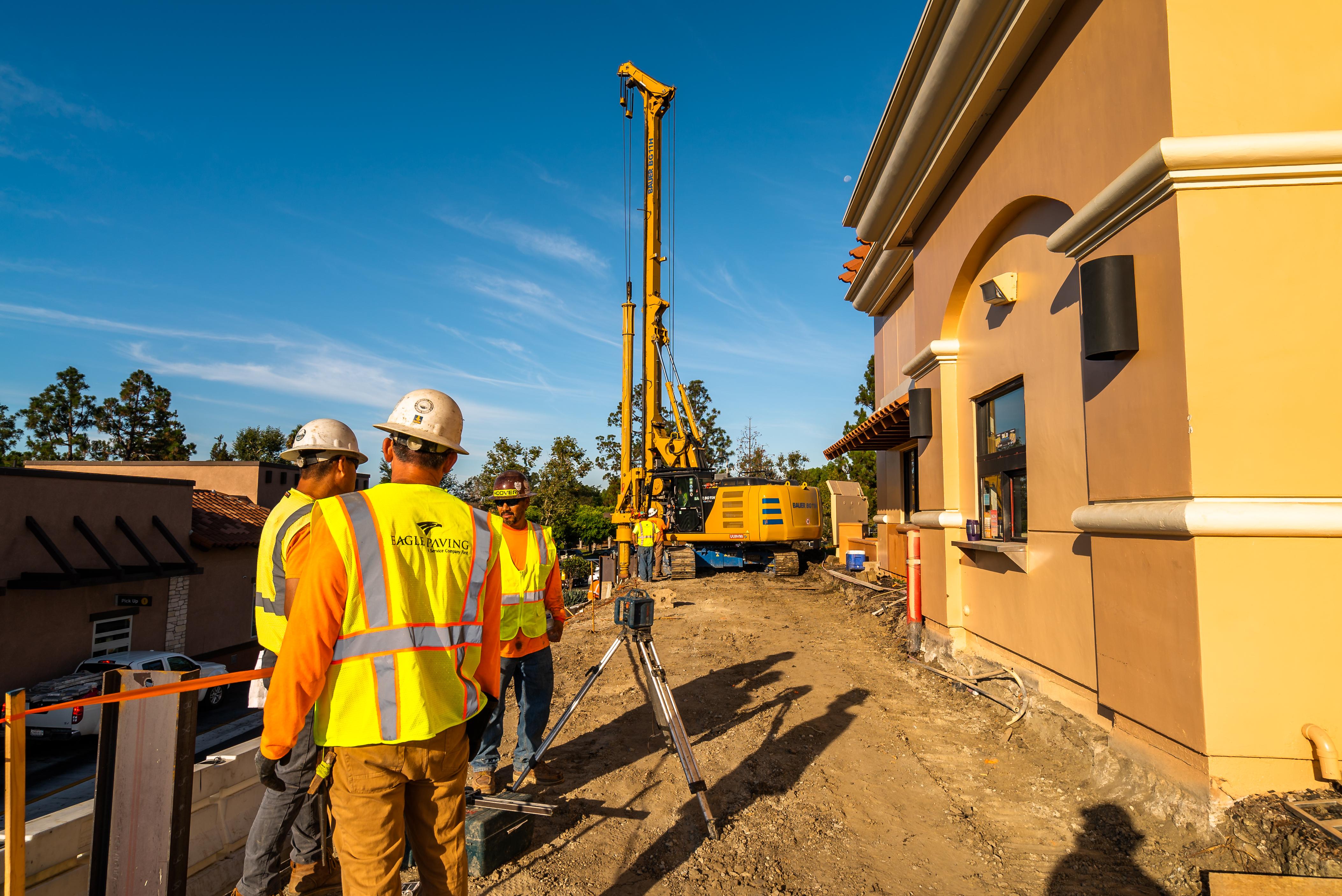 Construction workers on site taking measurements and readings