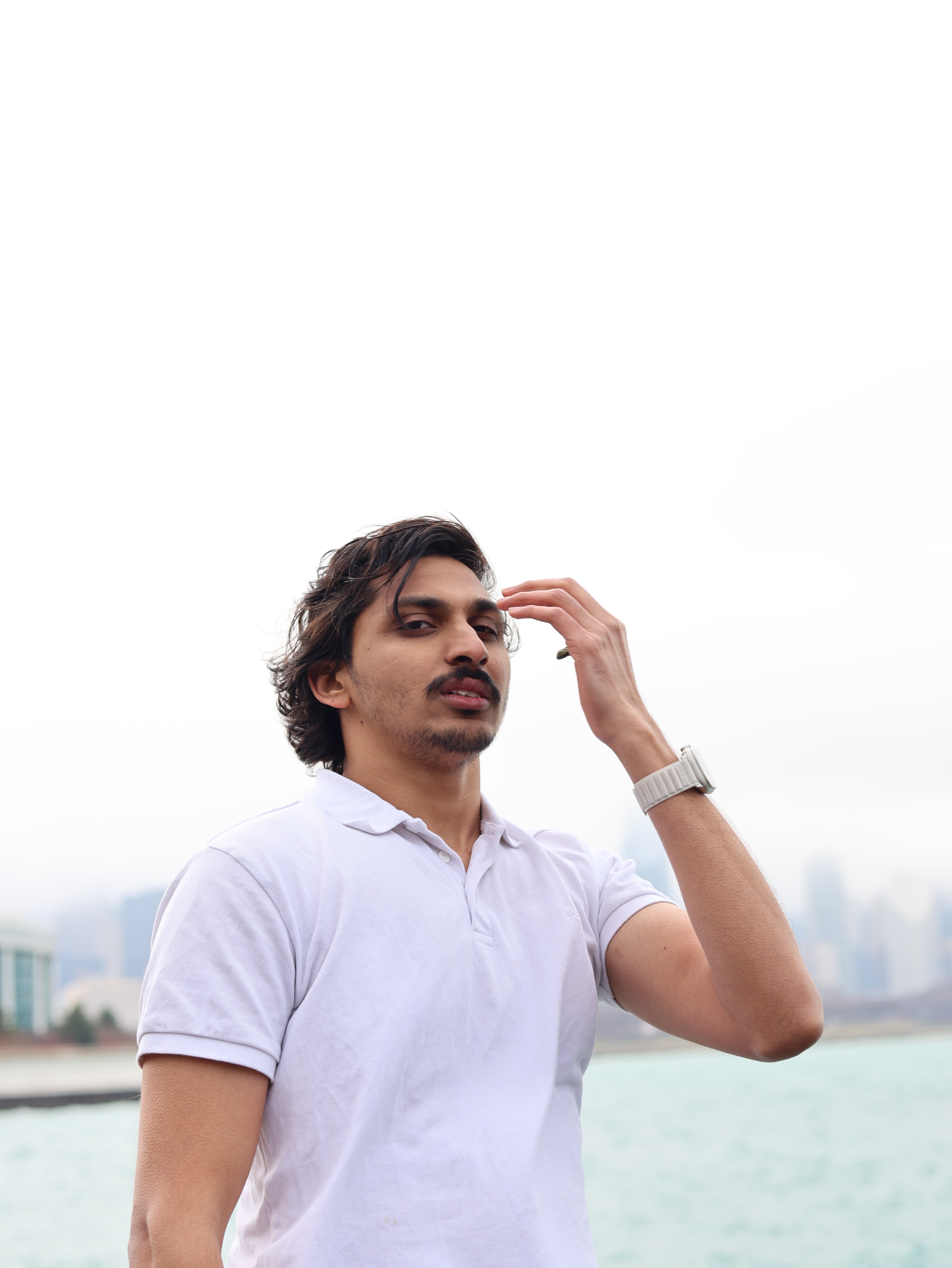 Woman working on a laptop computer at a table in a bright room.