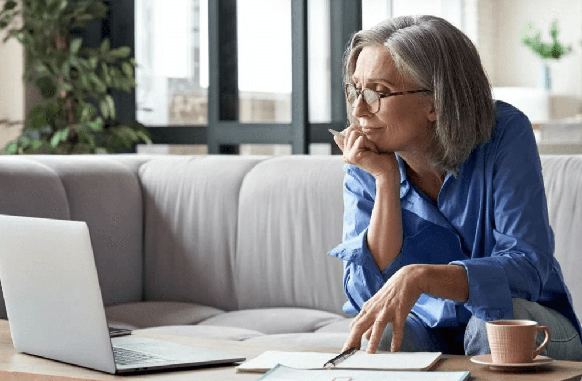 woman sitting on couch looking at laptop computer
