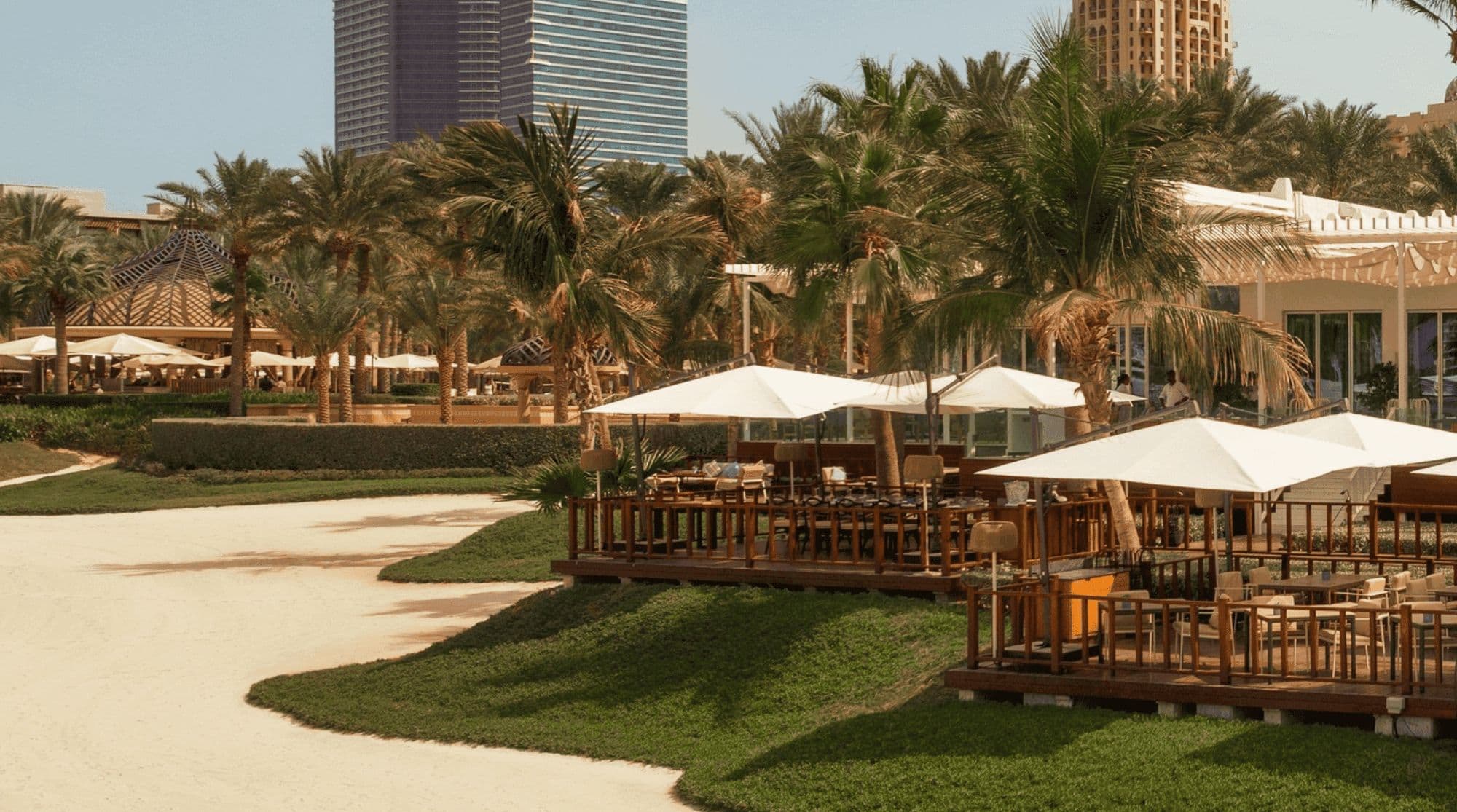 A palm-lined beach restaurant in Dubai with woodend decking and shaded dining areas.
