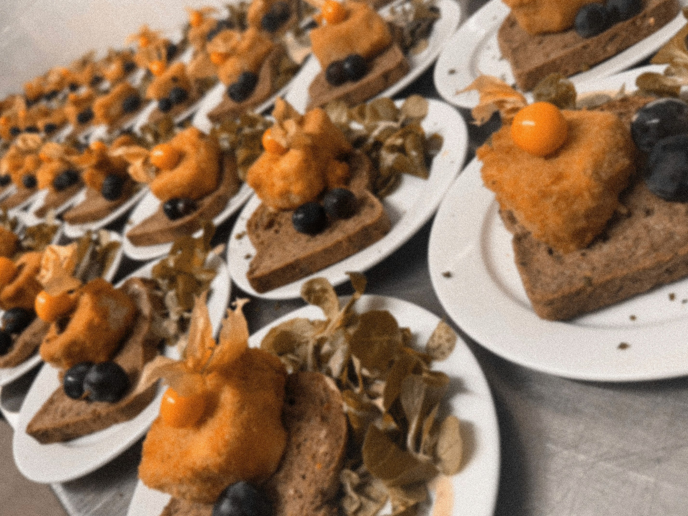 Modern indoor space with large glass doors, lush greenery, and a cozy seating area visible beyond.