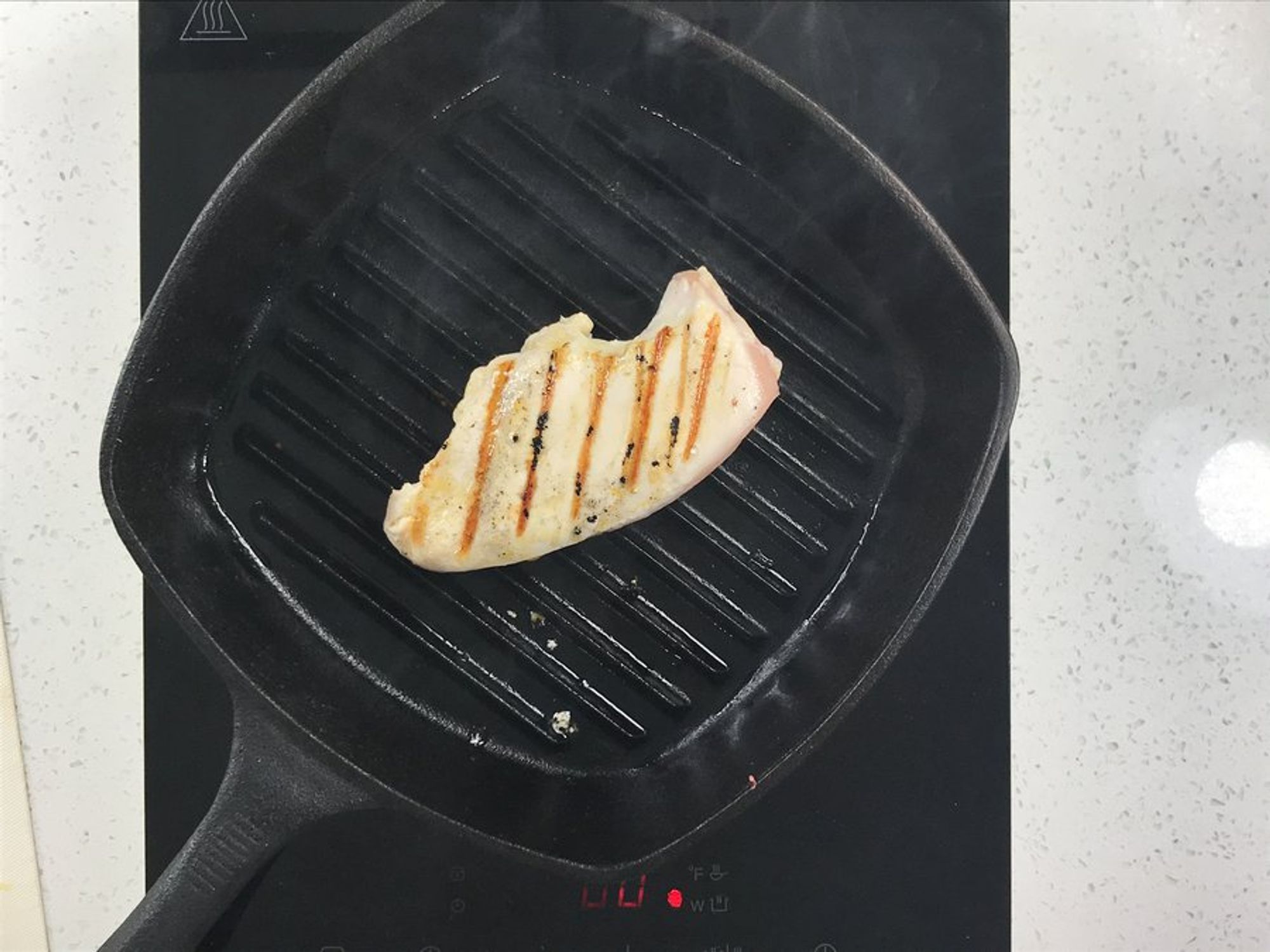 seasoned chicken breast being grilled