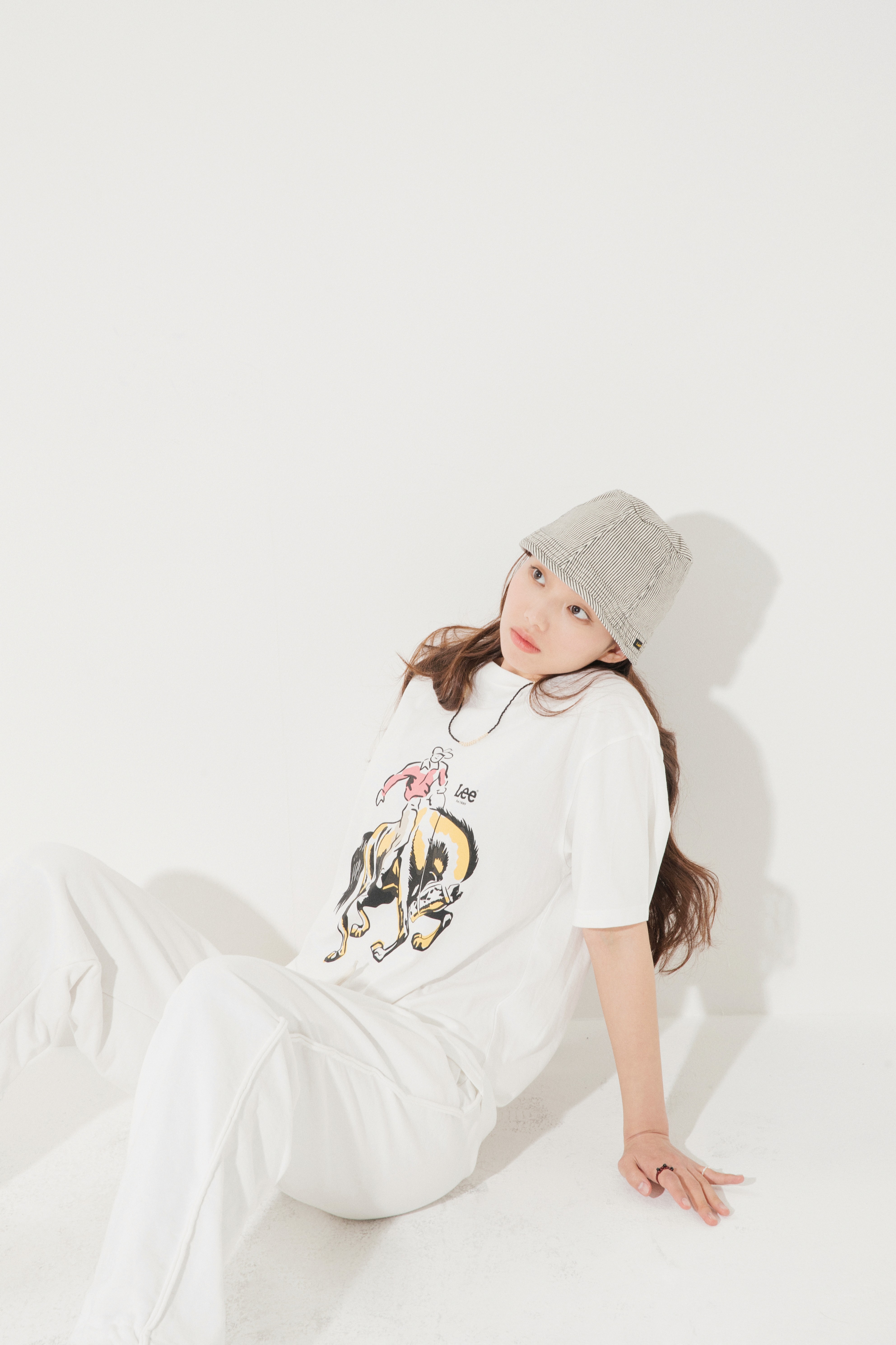 Top-down view of a bowl of white foaming cleanser with airy bubbles on a minimal surface.