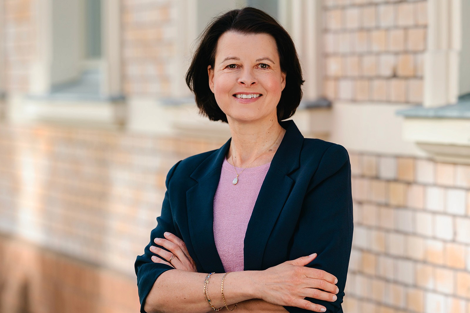 Dr. Sabine Jung steht lächelnd vor einer Wand