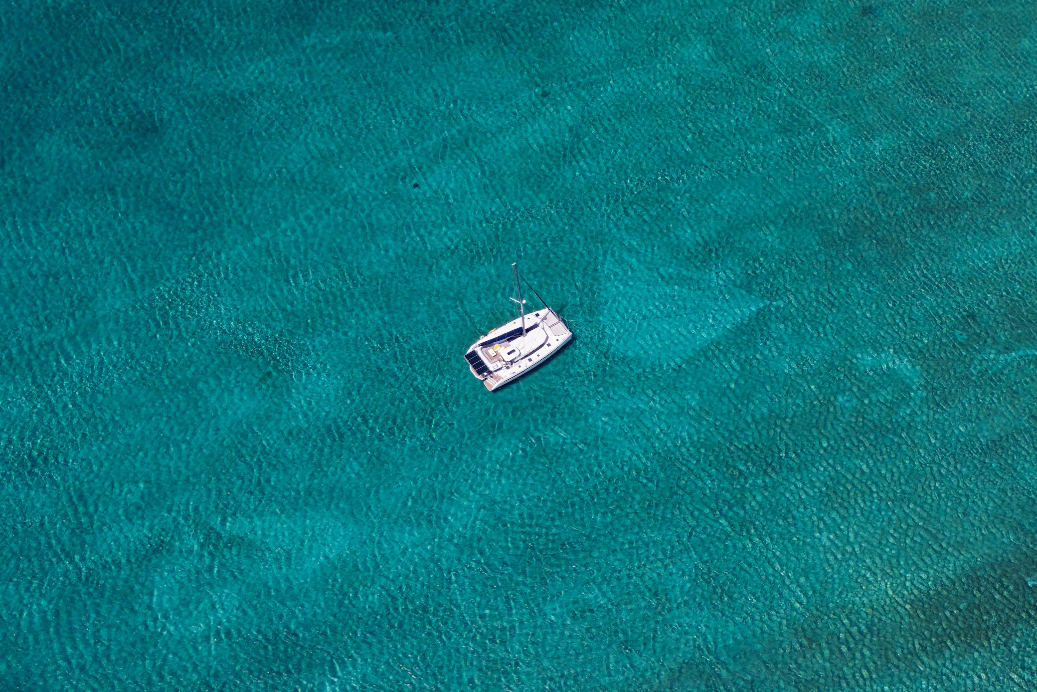 Un catamaran à faible tirant d’eau au mouillage sur les hauts-fonds turquoise des Abacos