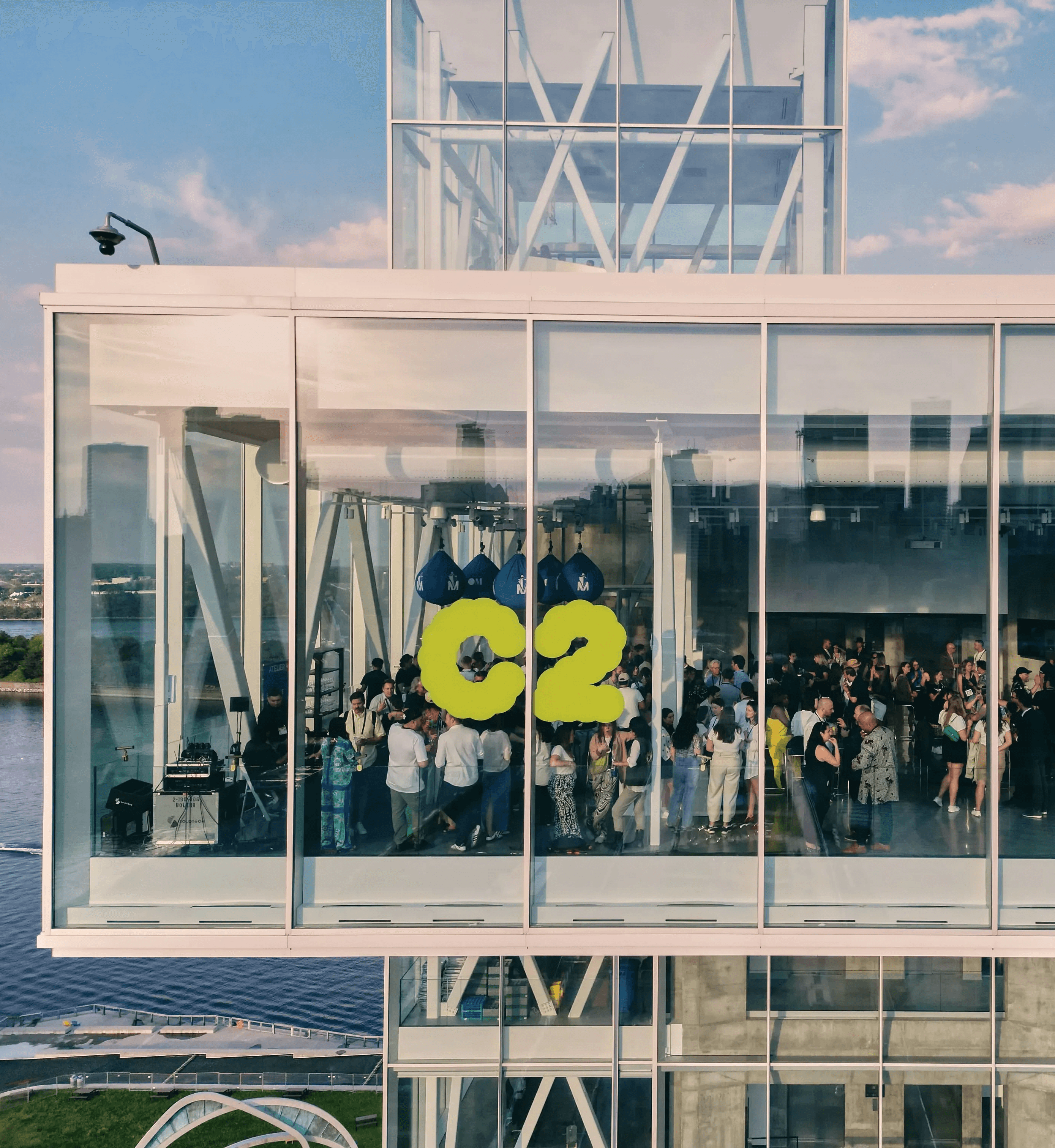 Attendees gathered behind glass windows featuring the C2 logo during a major conference moment.