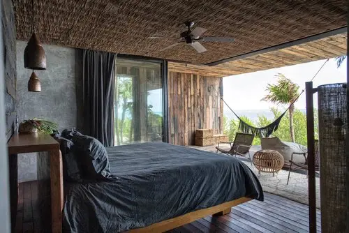 Bedroom at Casa Sastran with ceiling fan, terrace, hammock, and outdoor seating.