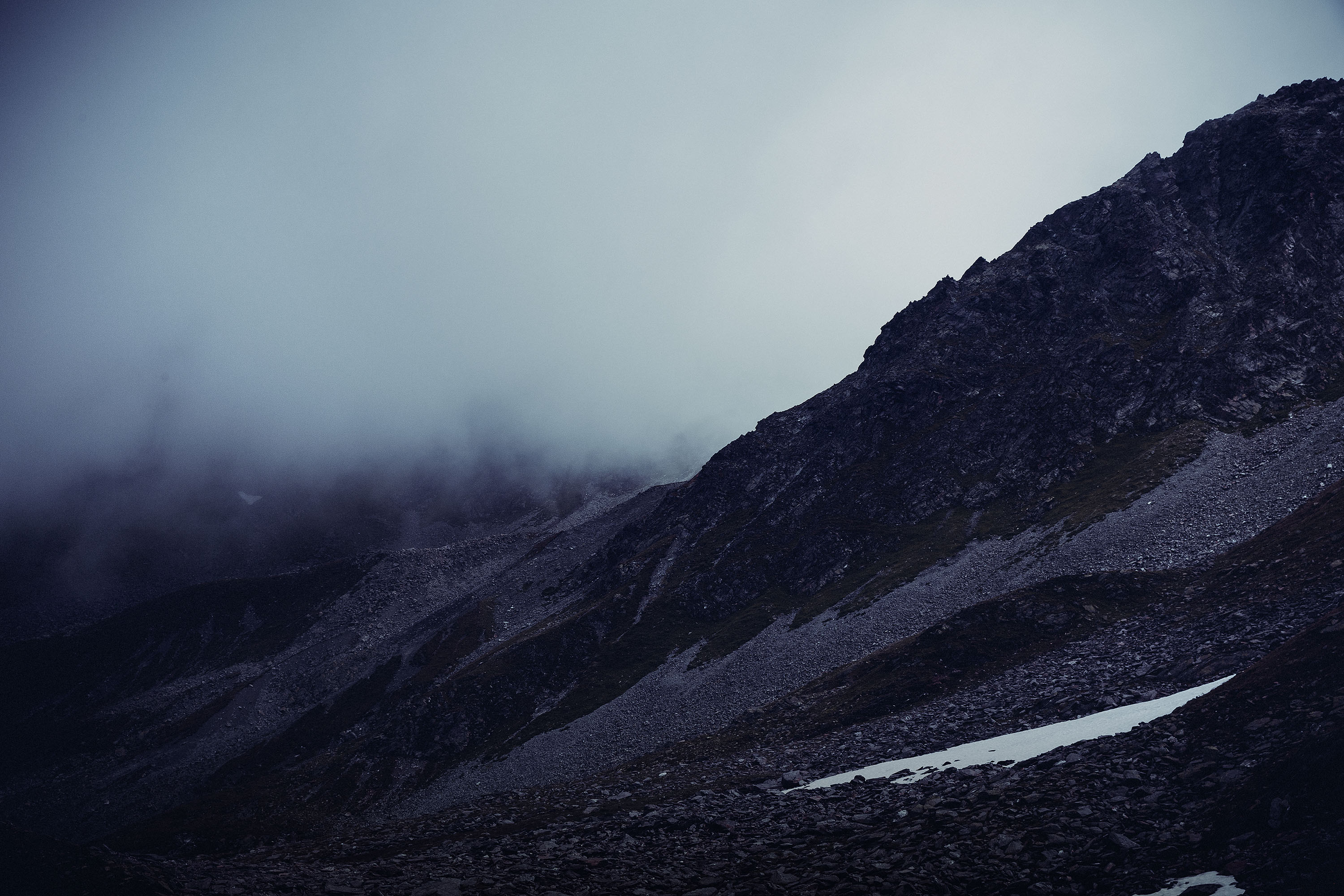 Image of dark mountain range with clouds passing through