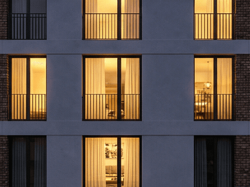 Abendstimmung in Remshalden. Der Neubau in der blauen Stunde, wobei das warme Licht aus den Fenstern der Wohnungen einladend strahlt und die hochwertige Architektur hervorhebt.