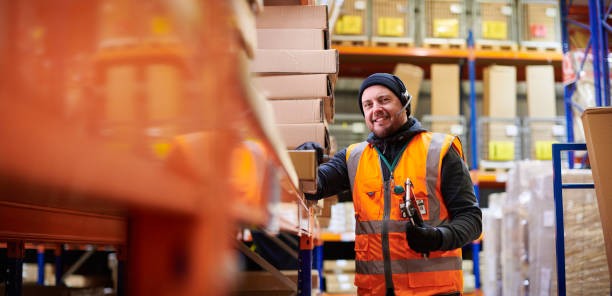 image of a man wearing orange high vis smiling inside of a warehouse