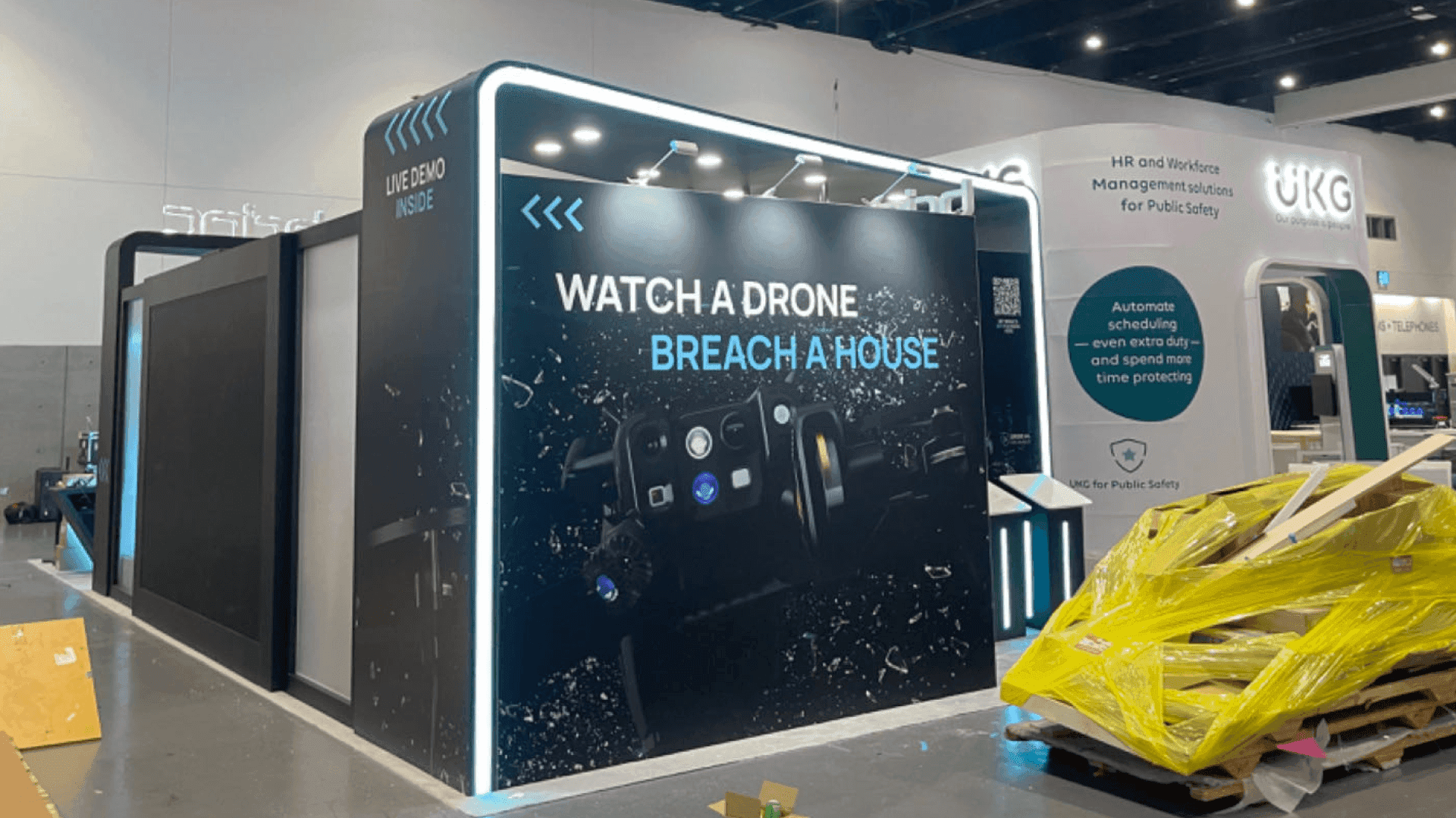 IACP 2026 move-in sequencing showing booth freight available for installation, a display vehicle spotted into final position, and firearms routed to the IACP Armory.