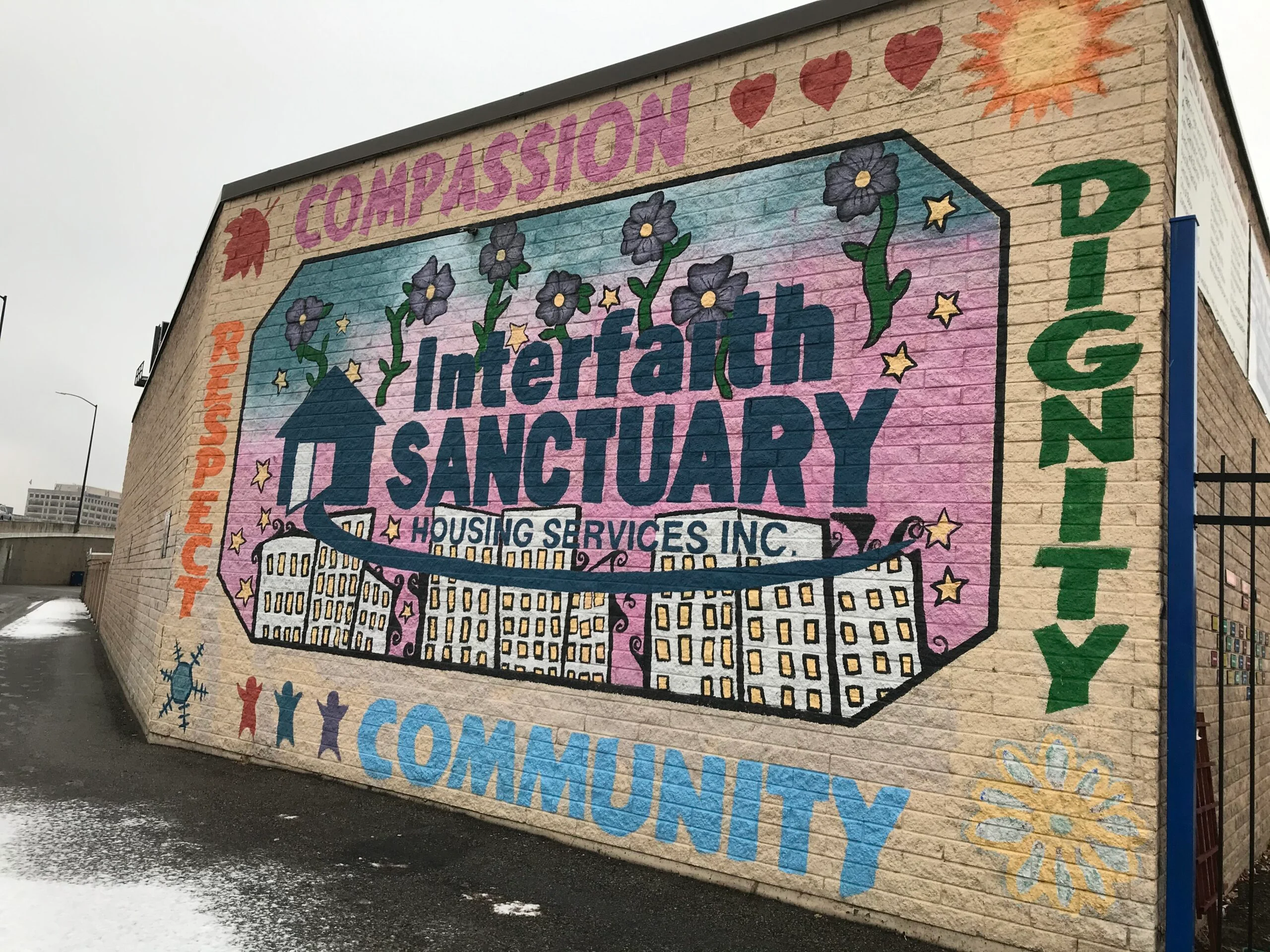 Wandbild am Interfaith-Sanctuary-Obdachlosenheim mit den Worten Mitgefühl, Respekt, Würde und Gemeinschaft