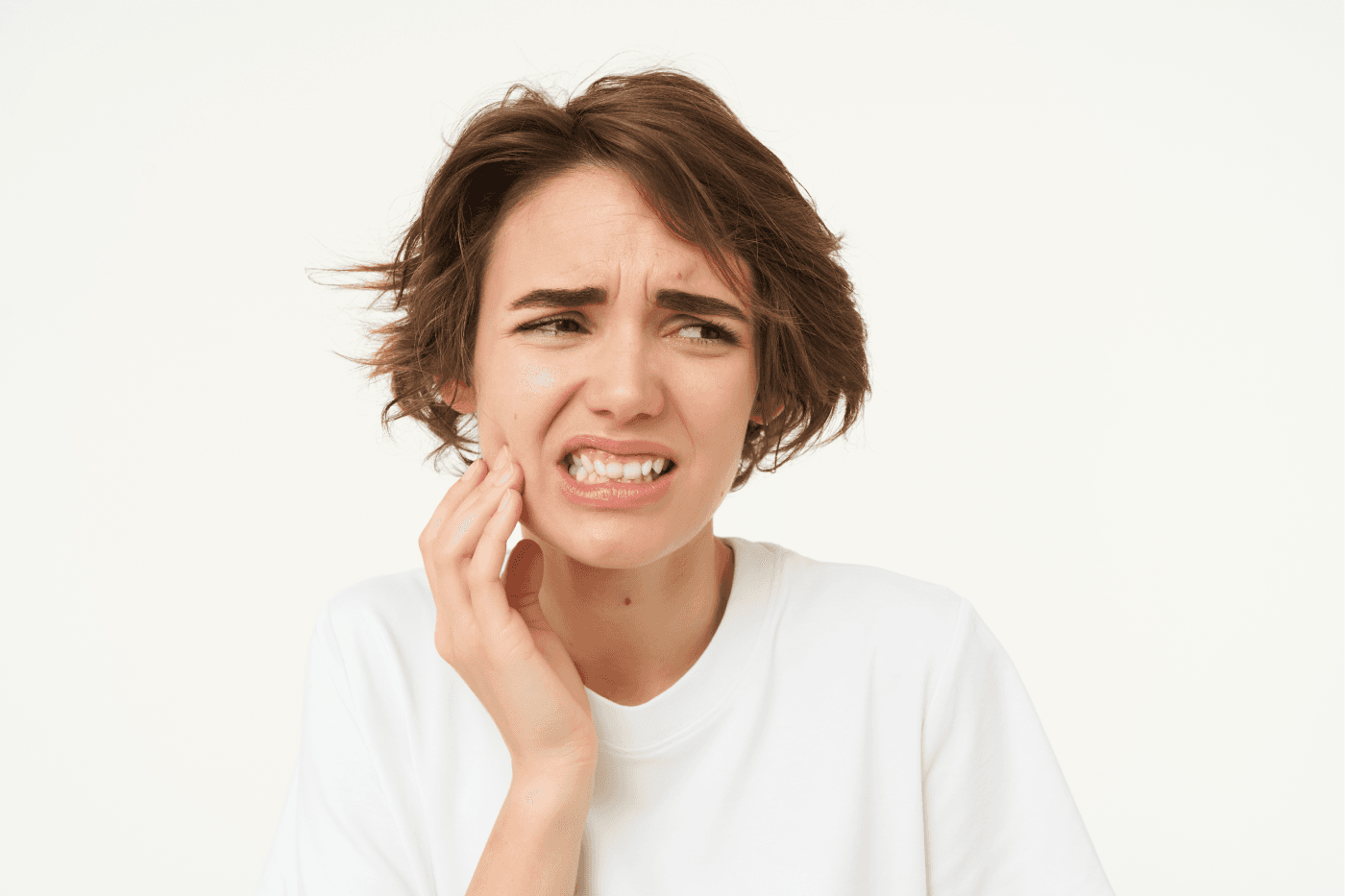 A person with dental pain holding their cheek, indicating discomfort.